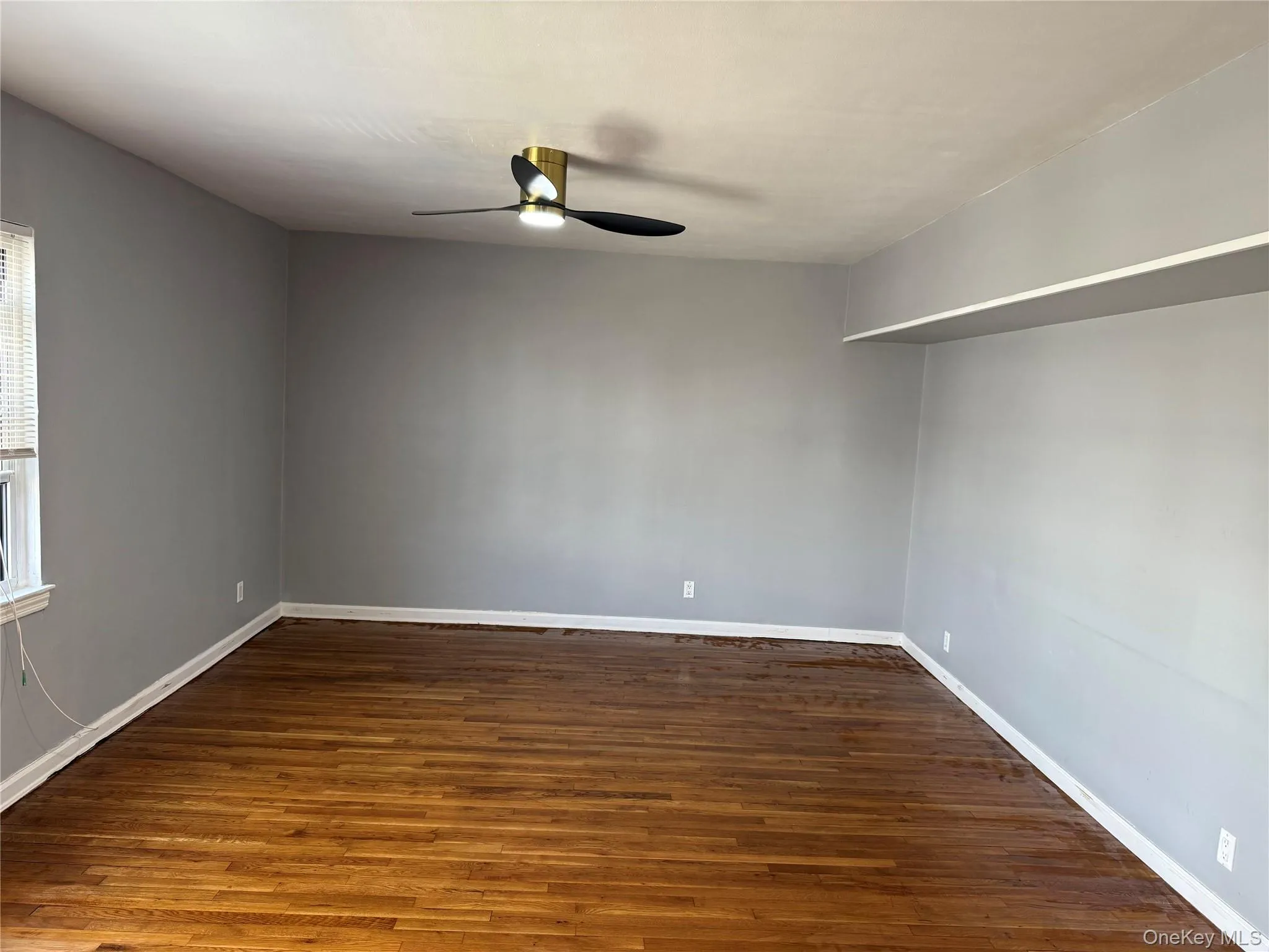 Empty room featuring a ceiling fan and wood finished floors Empty room featuring a ceiling fan and wood finished floors