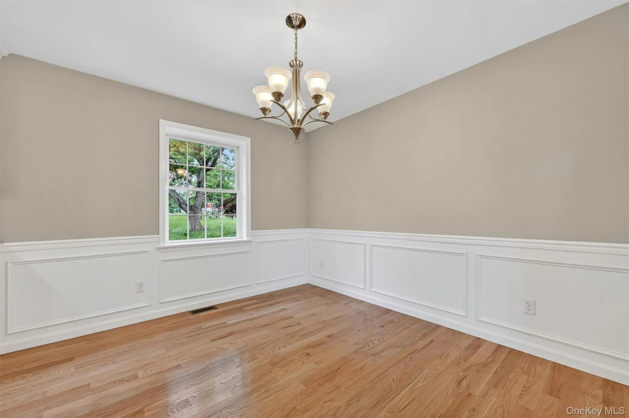 Hardwood flooring complemented by wainscoting and crown molding Hardwood flooring complemented by wainscoting and crown molding