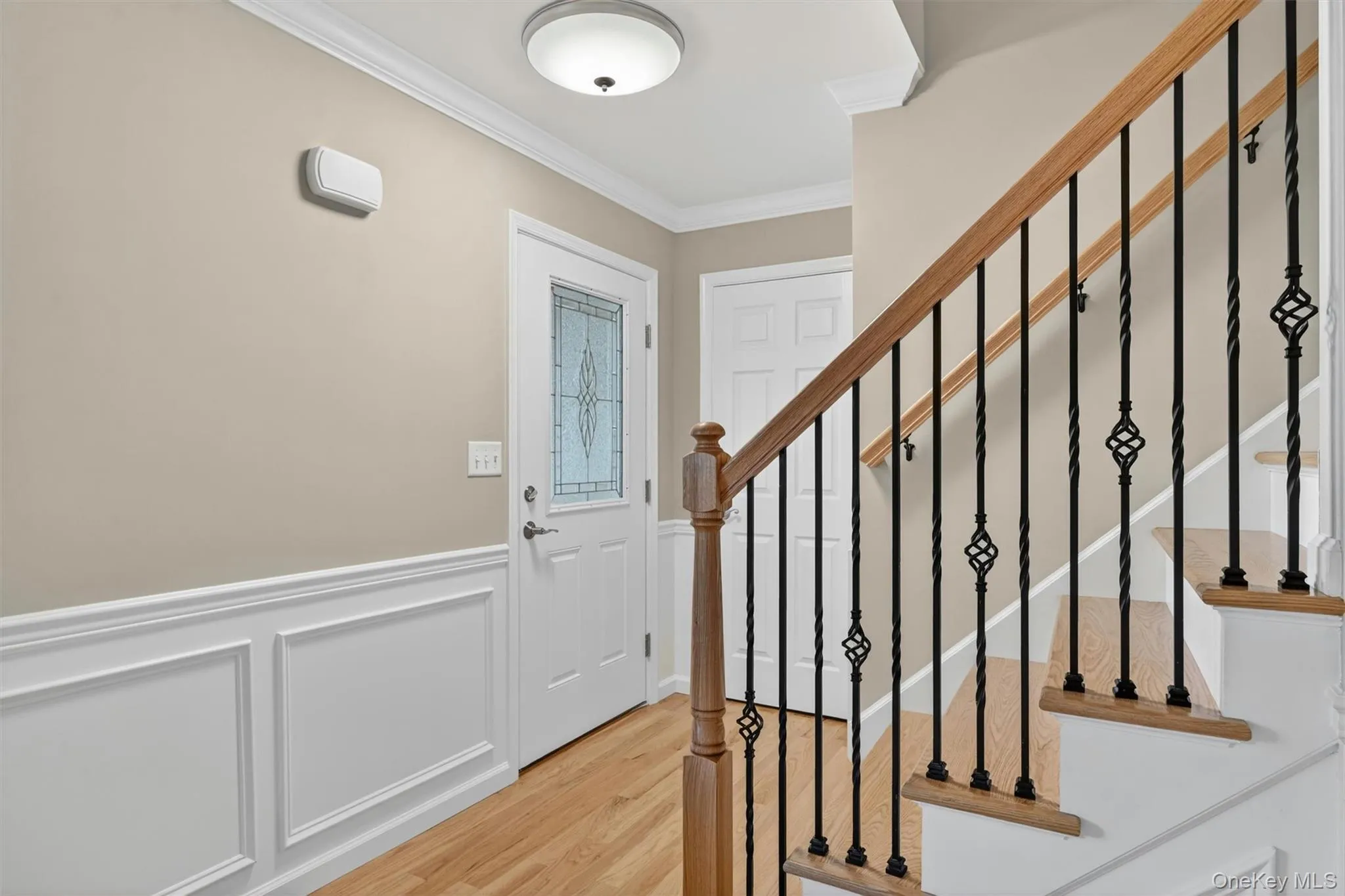 Grand staircase featuring wood-finish treads, painted risers, and wrought iron balusters Grand staircase featuring wood-finish treads, painted risers, and wrought iron balusters