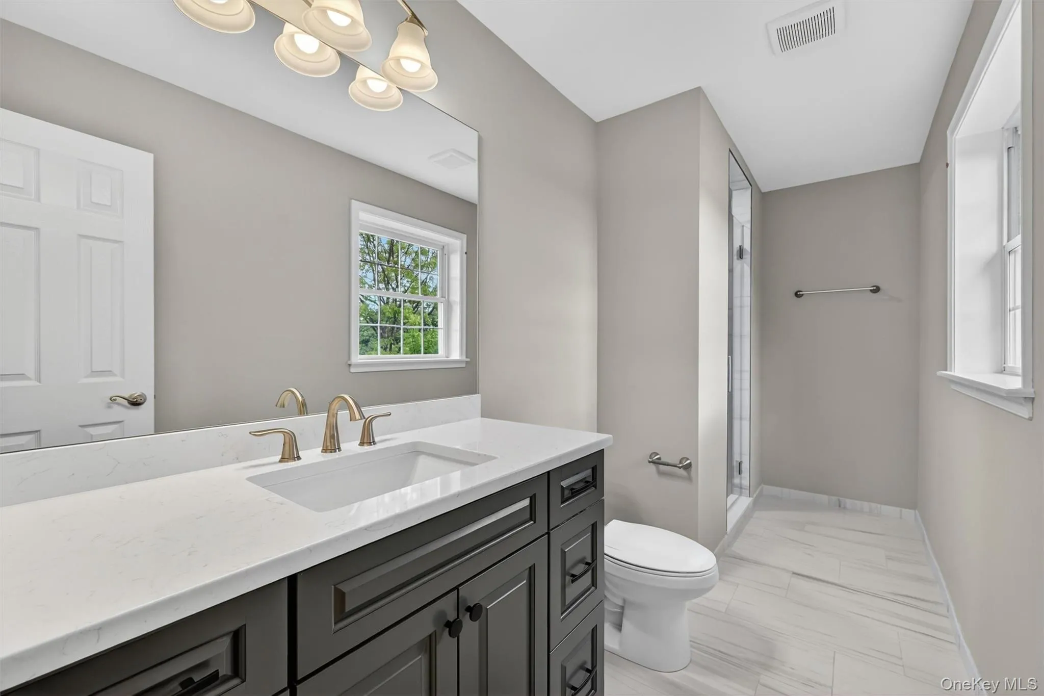 Contemporary bathroom featuring a dark wood-finish vanity with a white countertop and undermount sink Contemporary bathroom featuring a dark wood-finish vanity with a white countertop and undermount sink