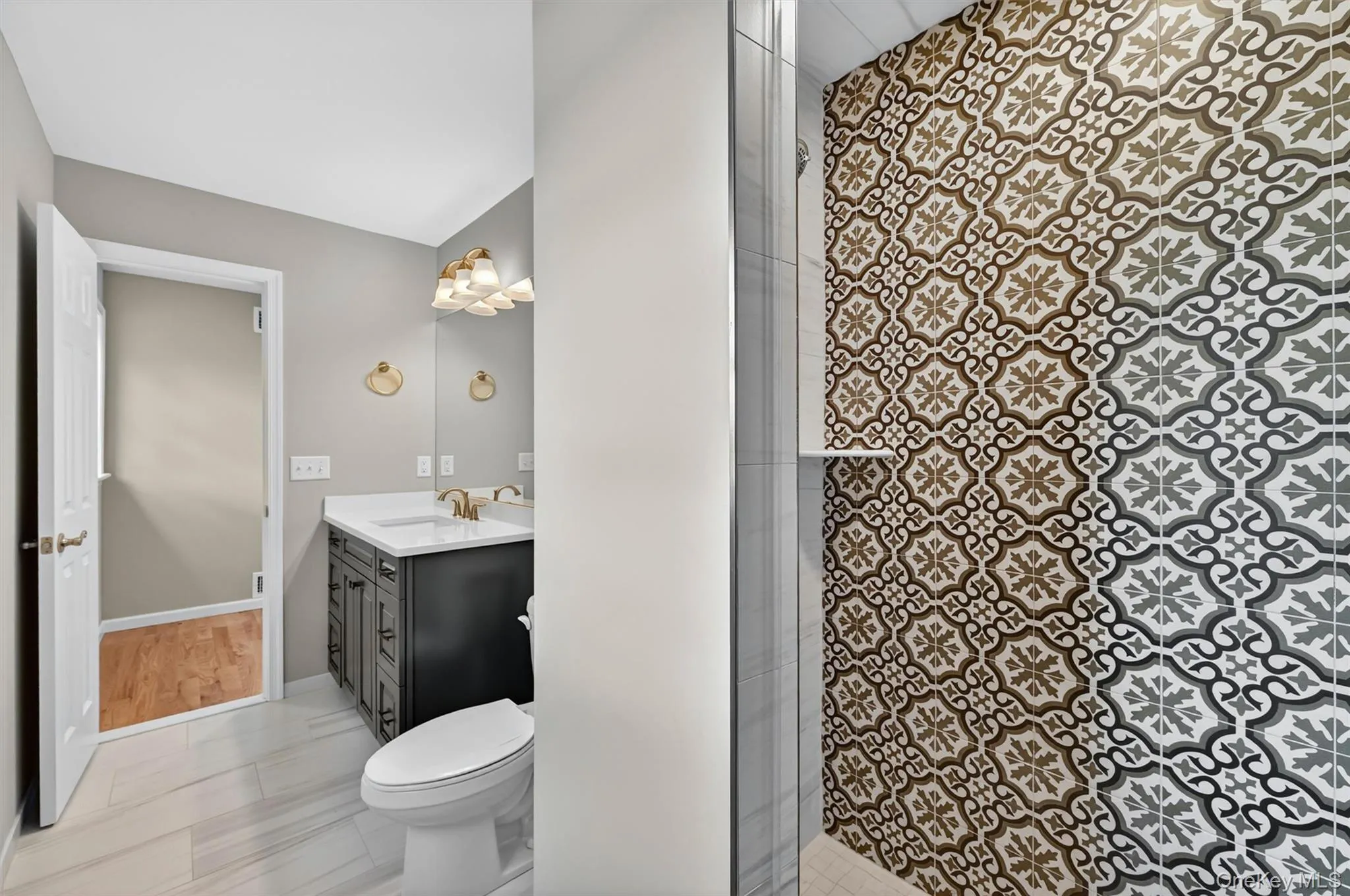 Shower with patterned tile surround, glass enclosure, and built-in shelf Shower with patterned tile surround, glass enclosure, and built-in shelf