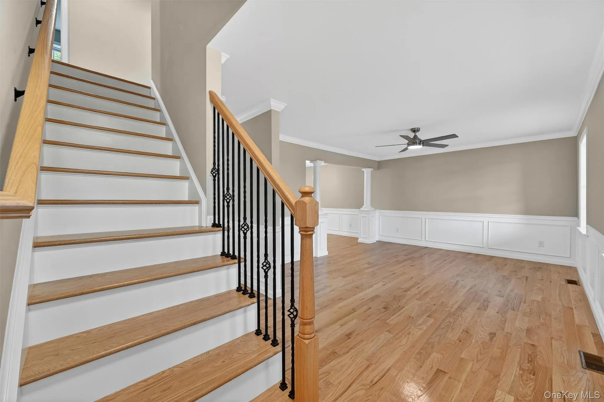 Grand staircase featuring wood-finish treads, painted risers, and wrought iron balusters Grand staircase featuring wood-finish treads, painted risers, and wrought iron balusters