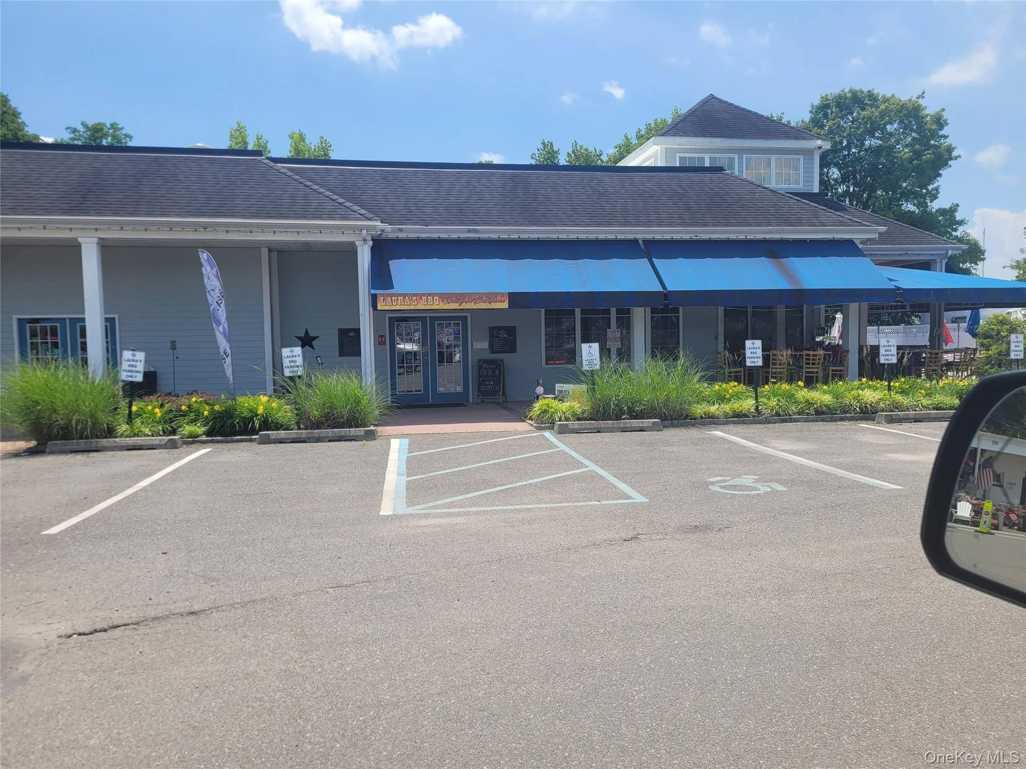 Commercial building with a prominent blue awning, light blue siding, and a dark shingle roof Commercial building with a prominent blue awning, light blue siding, and a dark shingle roof