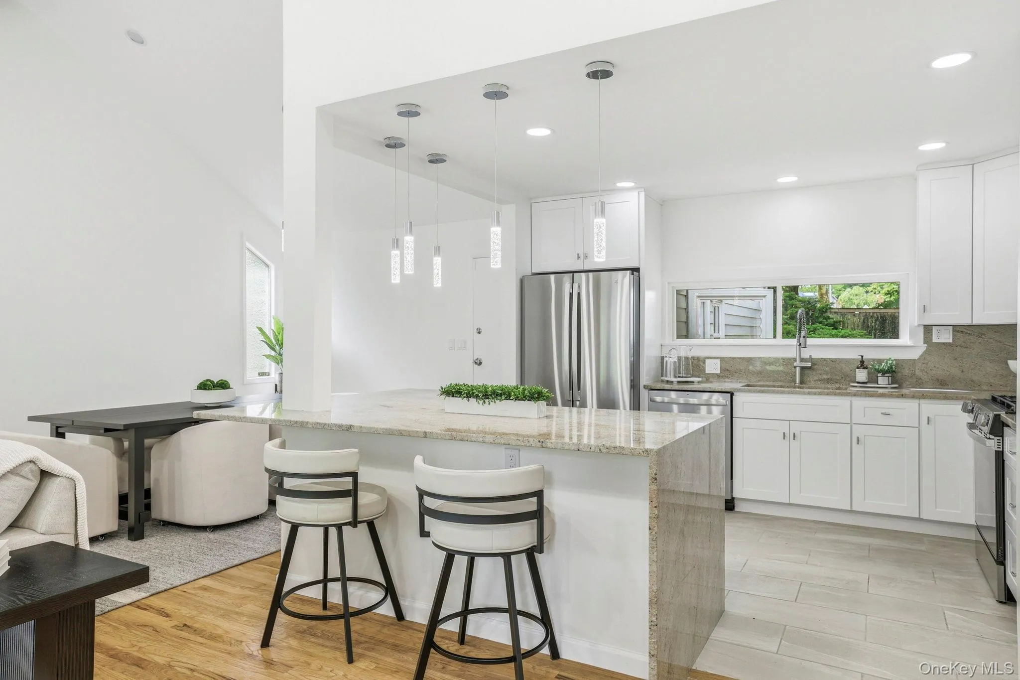 Renovated kitchen with stainless steel appliances and waterfall granite counter and backsplash Renovated kitchen with stainless steel appliances and waterfall granite counter and backsplash