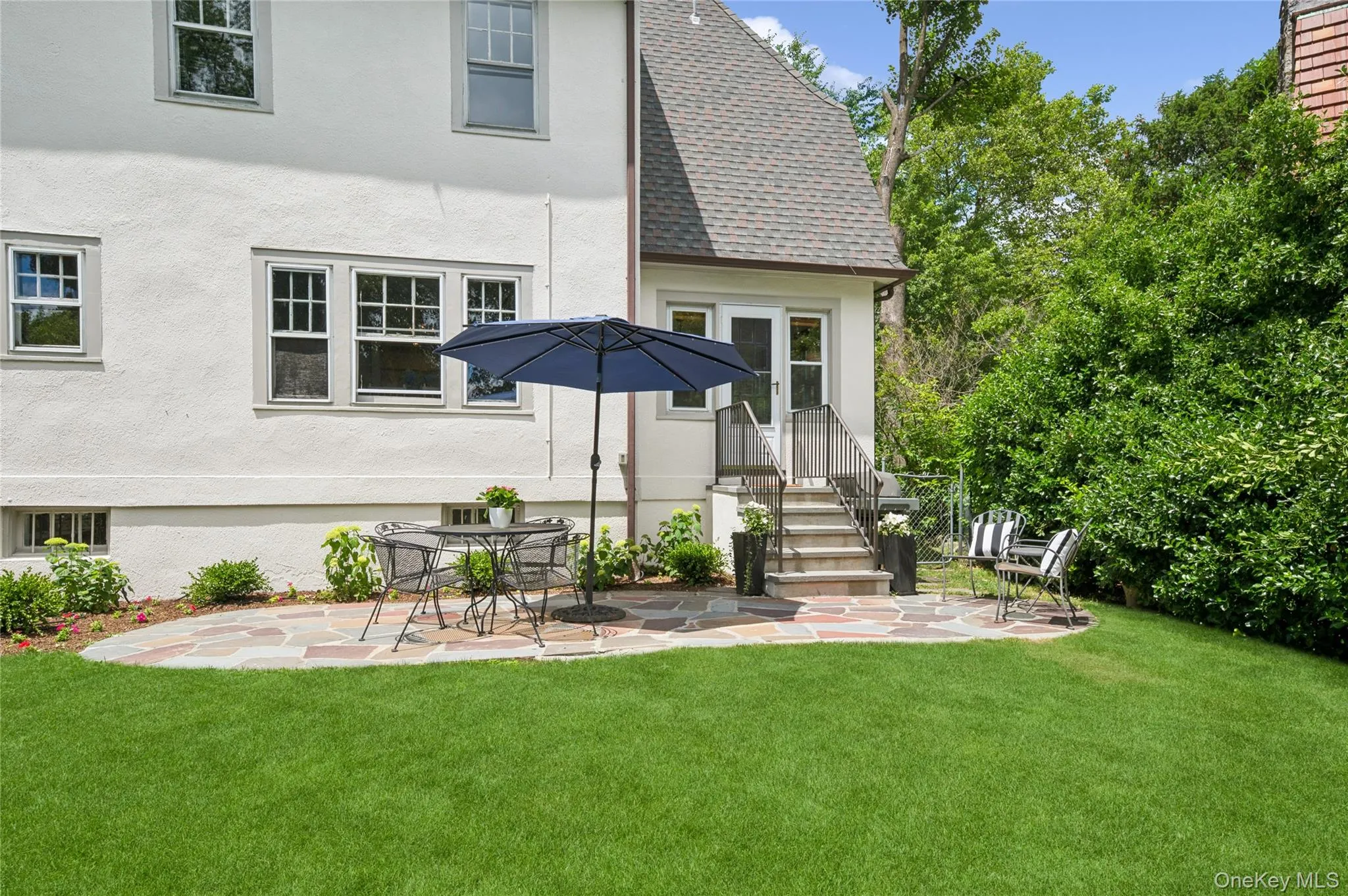 Expansive green lawn with a flagstone patio Expansive green lawn with a flagstone patio