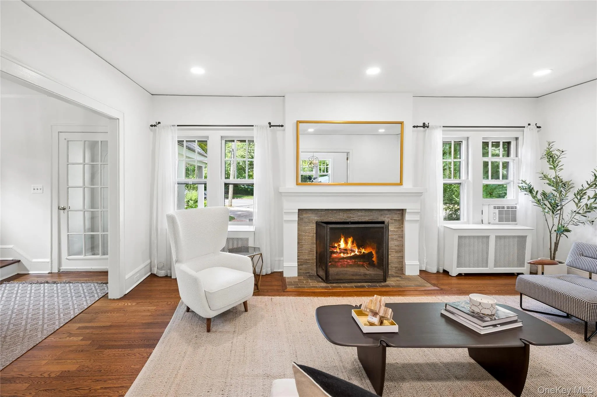 Living room featuring a fireplace with stone surround and classic mantel Living room featuring a fireplace with stone surround and classic mantel