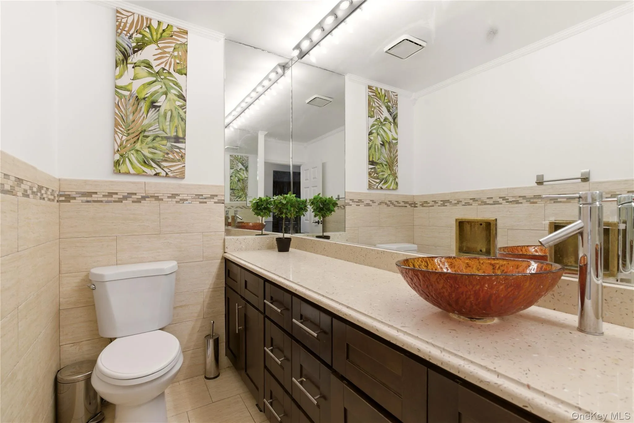 Vanity featuring a vessel sink with a contemporary faucet, expansive mirror, and accent lighting Vanity featuring a vessel sink with a contemporary faucet, expansive mirror, and accent lighting