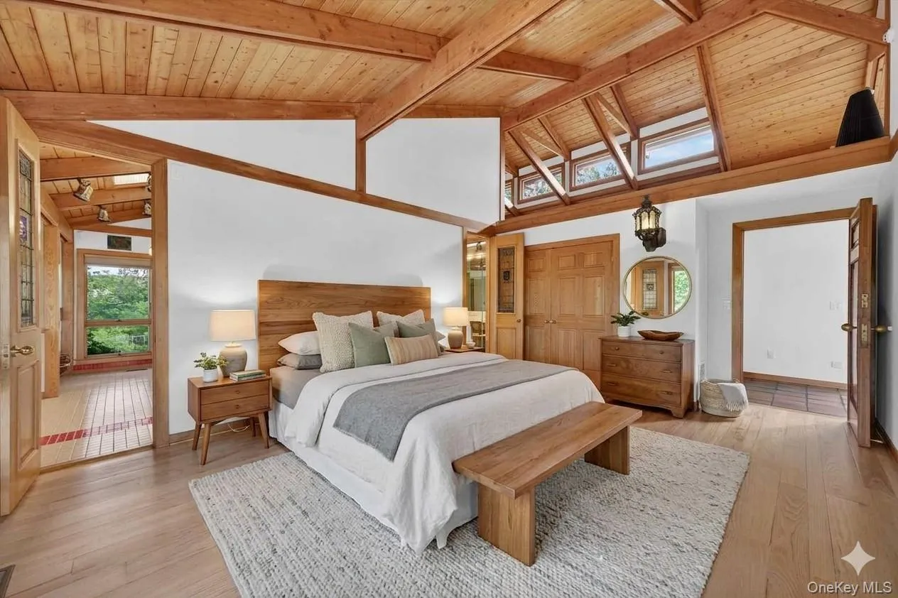 The primary suite is conveniently located on the main level and features a cool open ceiling with wood beams and gleaming floors*virtually staged* The primary suite is conveniently located on the main level and features a cool open ceiling with wood beams and gleaming floors*virtually staged*