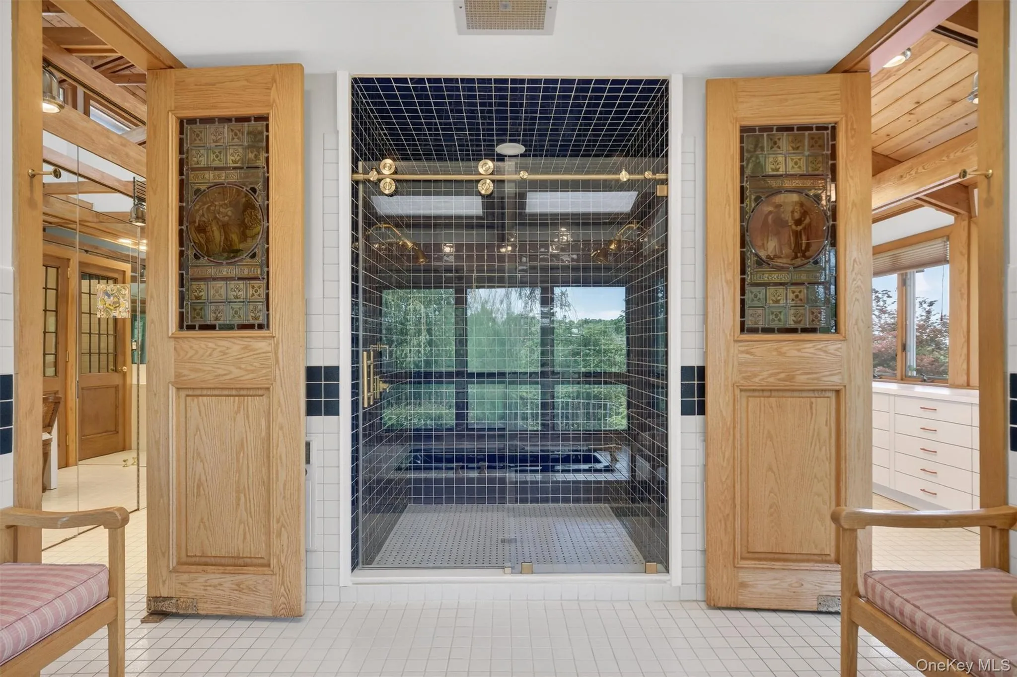 Extensive tile work, stained glass doors and a lovely soaking tub complement the large primary en suite Extensive tile work, stained glass doors and a lovely soaking tub complement the large primary en suite