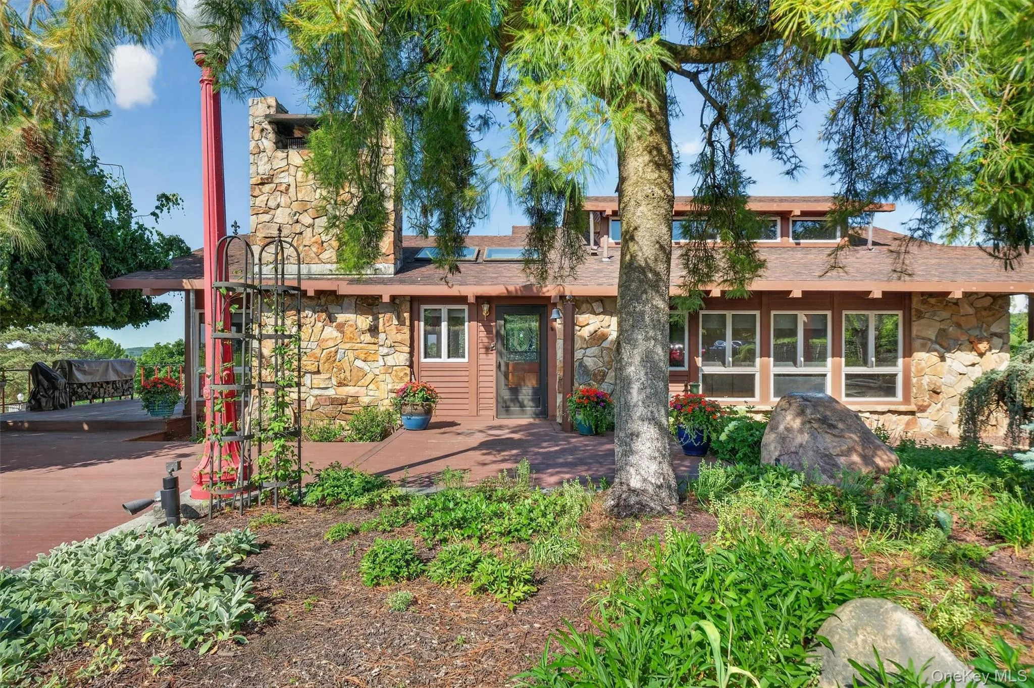 Tucked away behind extensive gardens, the wood and stone home blends seamlessly with the property Tucked away behind extensive gardens, the wood and stone home blends seamlessly with the property