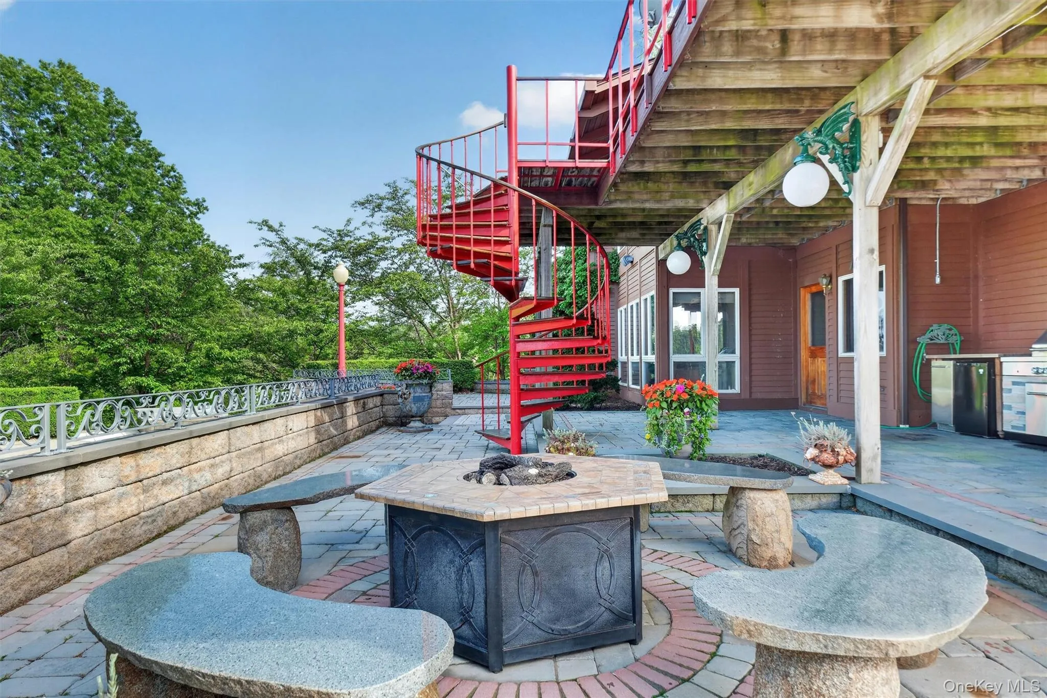 Beautiful stone, tile and granite carved fire pit area by the pool. Note the spiral staircase from the top deck Beautiful stone, tile and granite carved fire pit area by the pool. Note the spiral staircase from the top deck