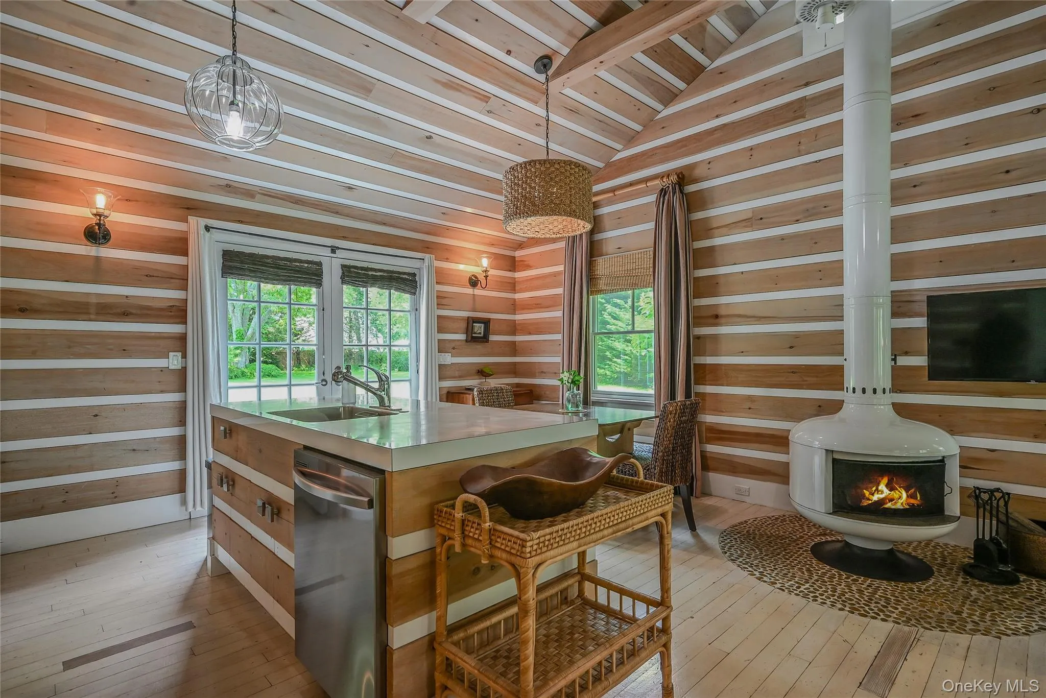 Kitchen featuring dishwasher, wood walls, wood ceiling, wood-type flooring, and a kitchen island with sink Kitchen featuring dishwasher, wood walls, wood ceiling, wood-type flooring, and a kitchen island with sink