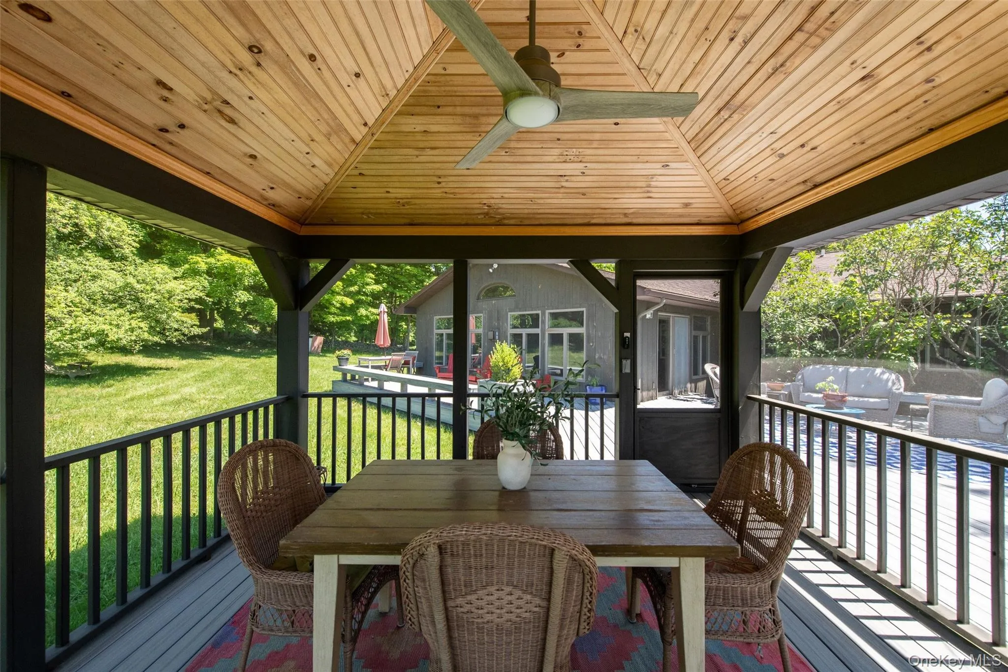 View of deck and back of house from screened gazebo with wood ceiling View of deck and back of house from screened gazebo with wood ceiling