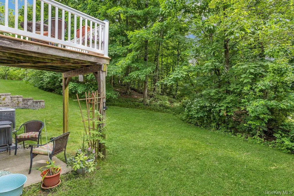 This beautiful green lawn separates the patio and the deck above it from the lovely wooded area beyond it. This beautiful green lawn separates the patio and the deck above it from the lovely wooded area beyond it.