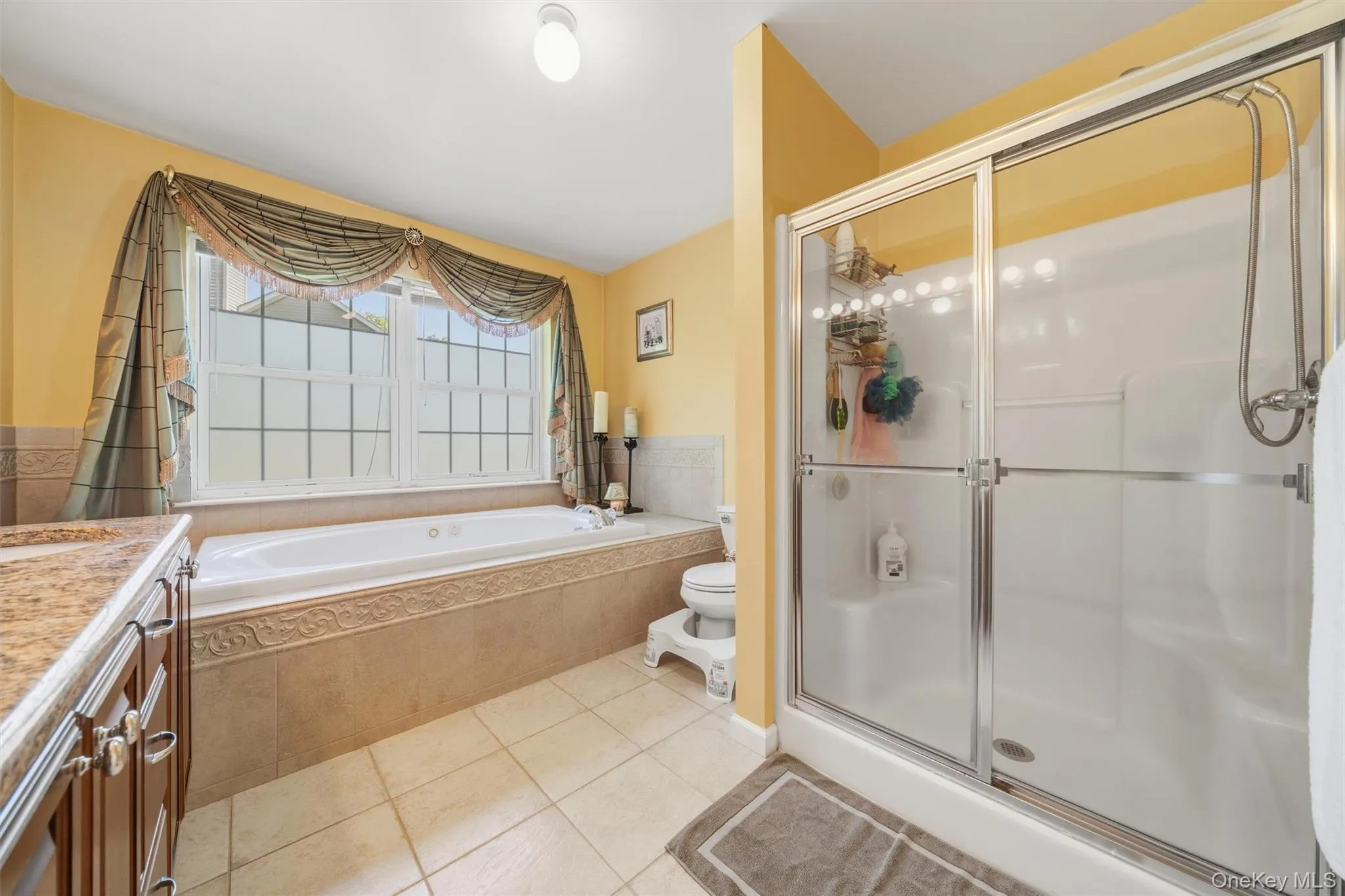 Primary En-suite Bathroom with Glass Door Shower, Double Sink, and Jetted Tub Primary En-suite Bathroom with Glass Door Shower, Double Sink, and Jetted Tub