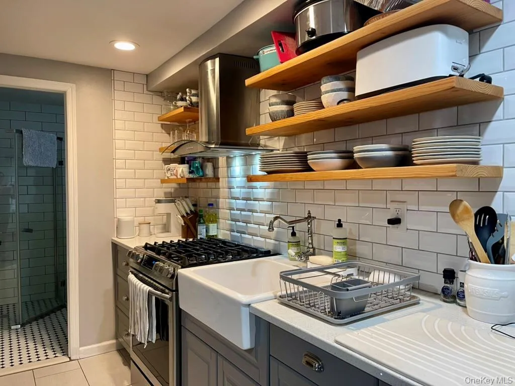 Kitchen with Quartz counters, porcelain farmhouse sink, open shelving, stainless appliances Kitchen with Quartz counters, porcelain farmhouse sink, open shelving, stainless appliances