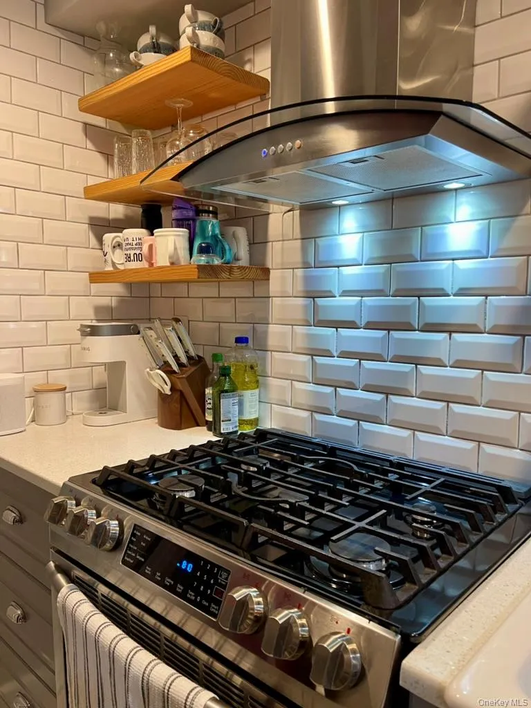 Kitchen with Quartz counters, porcelain farmhouse sink, open shelving, stainless appliances Kitchen with Quartz counters, porcelain farmhouse sink, open shelving, stainless appliances