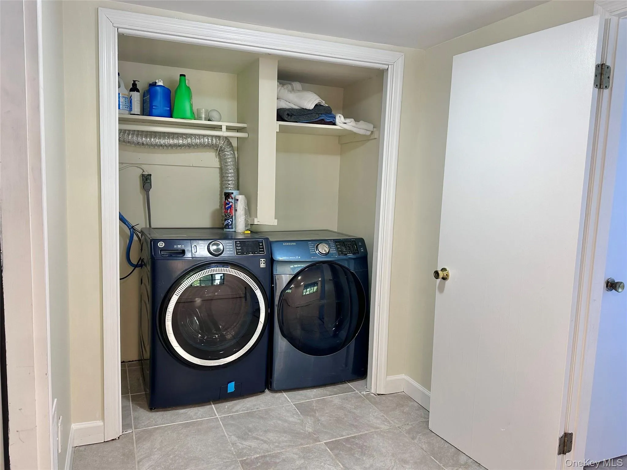Laundry room featuring independent washer and dryer and tile patterned floors Laundry room featuring independent washer and dryer and tile patterned floors