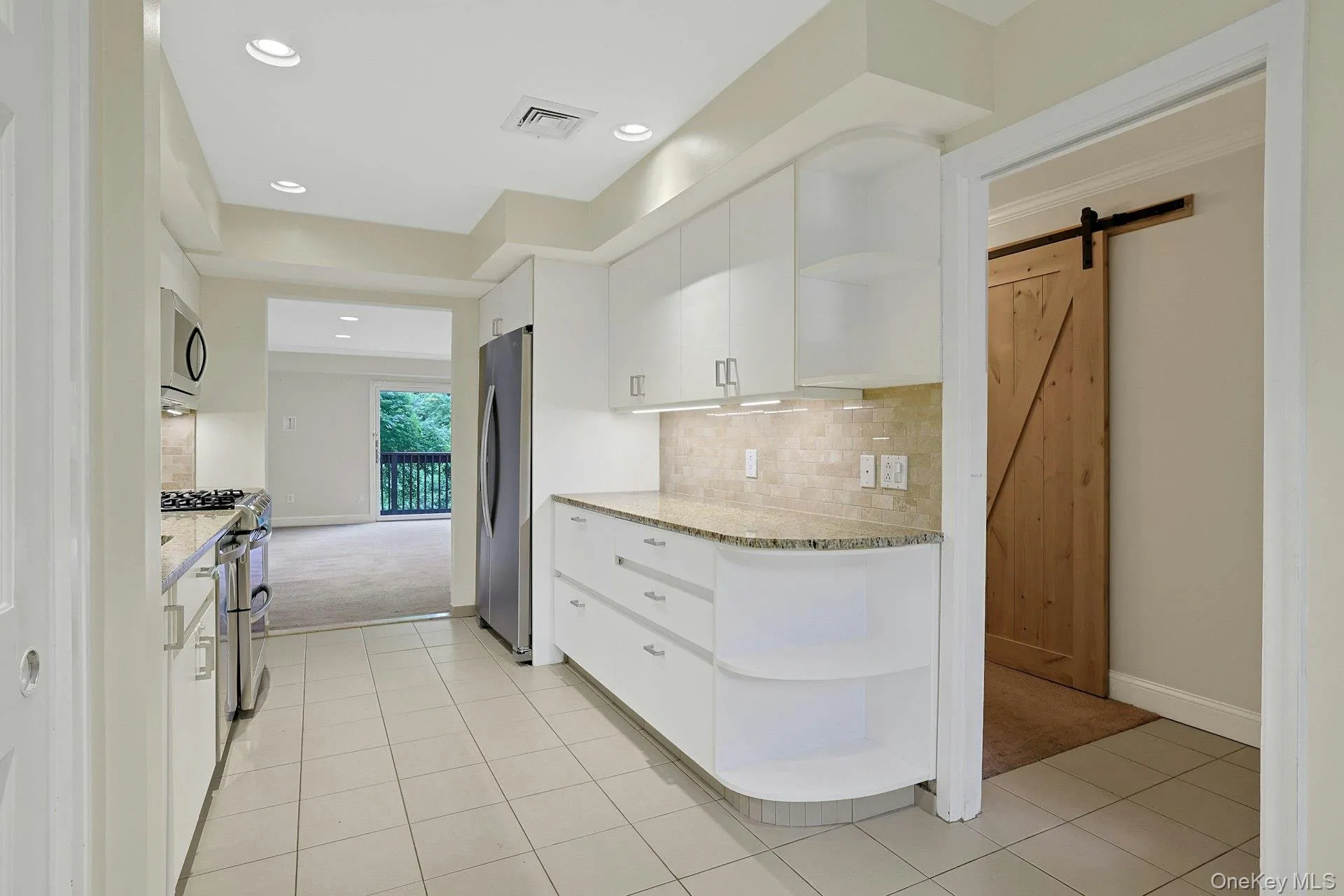 Kitchen has a pocket door to the right. View on right towards entry foyer and den Kitchen has a pocket door to the right. View on right towards entry foyer and den