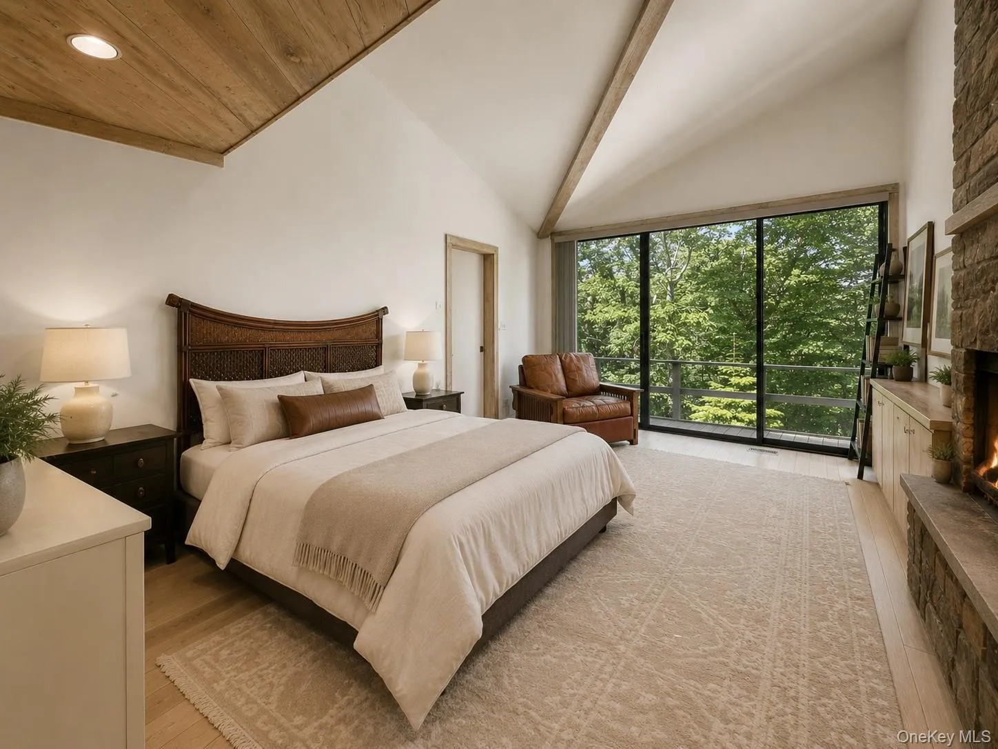 Spacious and inviting primary suite featuring soaring cathedral ceilings and a beautiful stone fireplace that adds warmth and charm. Sliding glass doors open directly to a private deck, surrounded by peaceful wooded views for a serene retreat-like feel. The suite also includes an attached primary bathroom and a generous walk-in closet area, offering both comfort and convenience. Spacious and inviting primary suite featuring soaring cathedral ceilings and a beautiful stone fireplace that adds warmth and charm. Sliding glass doors open directly to a private deck, surrounded by peaceful wooded views for a serene retreat-like feel. The suite also includes an attached primary bathroom and a generous walk-in closet area, offering both comfort and convenience.