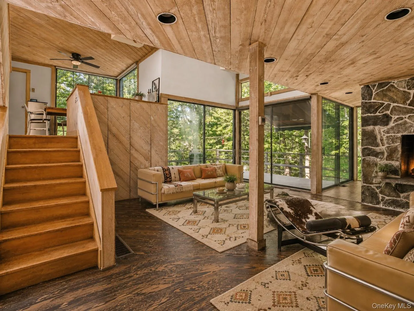 Spacious Living room with cathedral ceilings, floor to ceiling windows, sliding glass doors and a beautiful stone fireplace Spacious Living room with cathedral ceilings, floor to ceiling windows, sliding glass doors and a beautiful stone fireplace