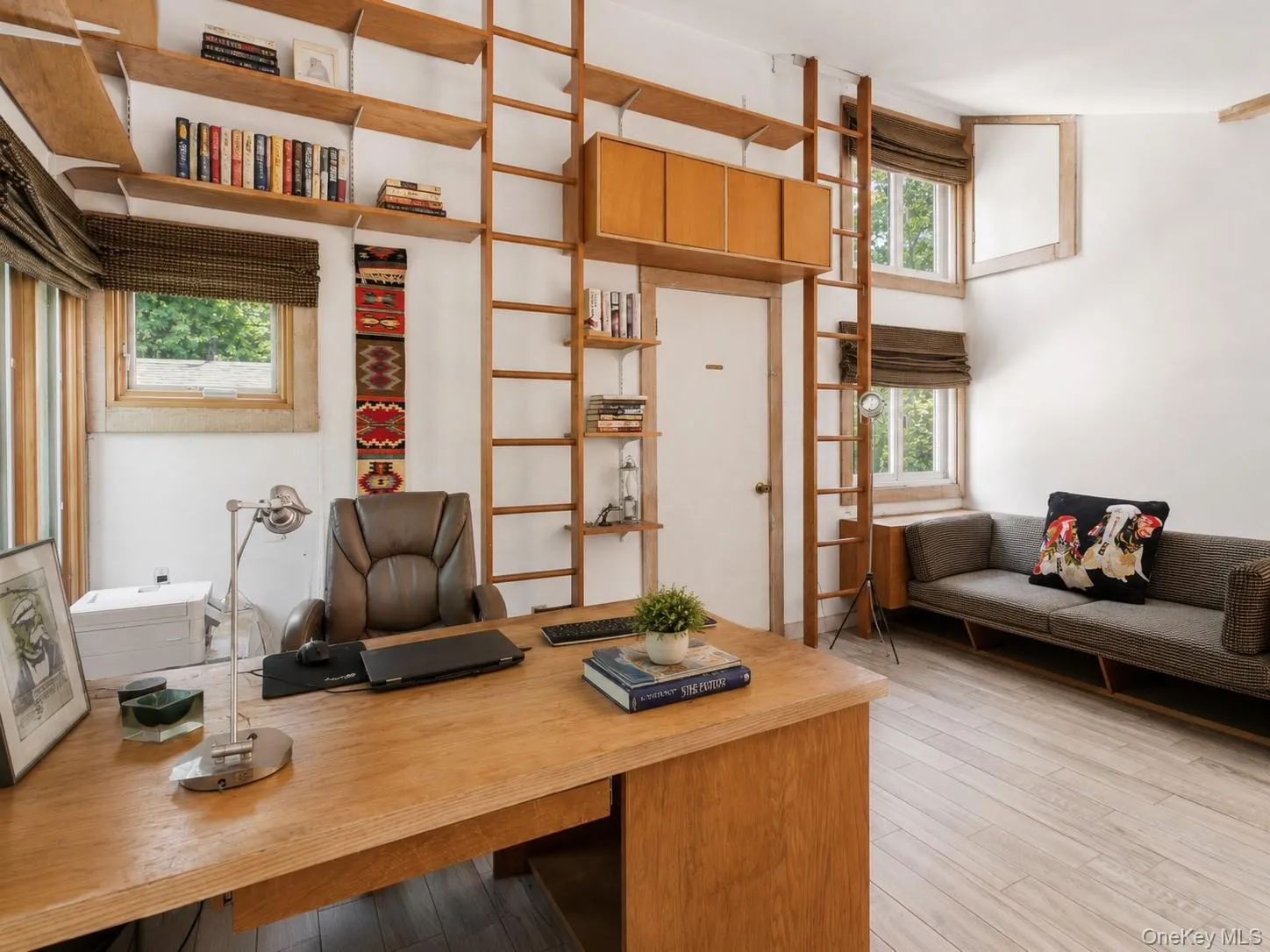 A striking loft library features soaring cathedral ceilings, unique architectural details, and floor-to-ceiling bookshelves with a classic library ladder for added charm and function. A striking loft library features soaring cathedral ceilings, unique architectural details, and floor-to-ceiling bookshelves with a classic library ladder for added charm and function.
