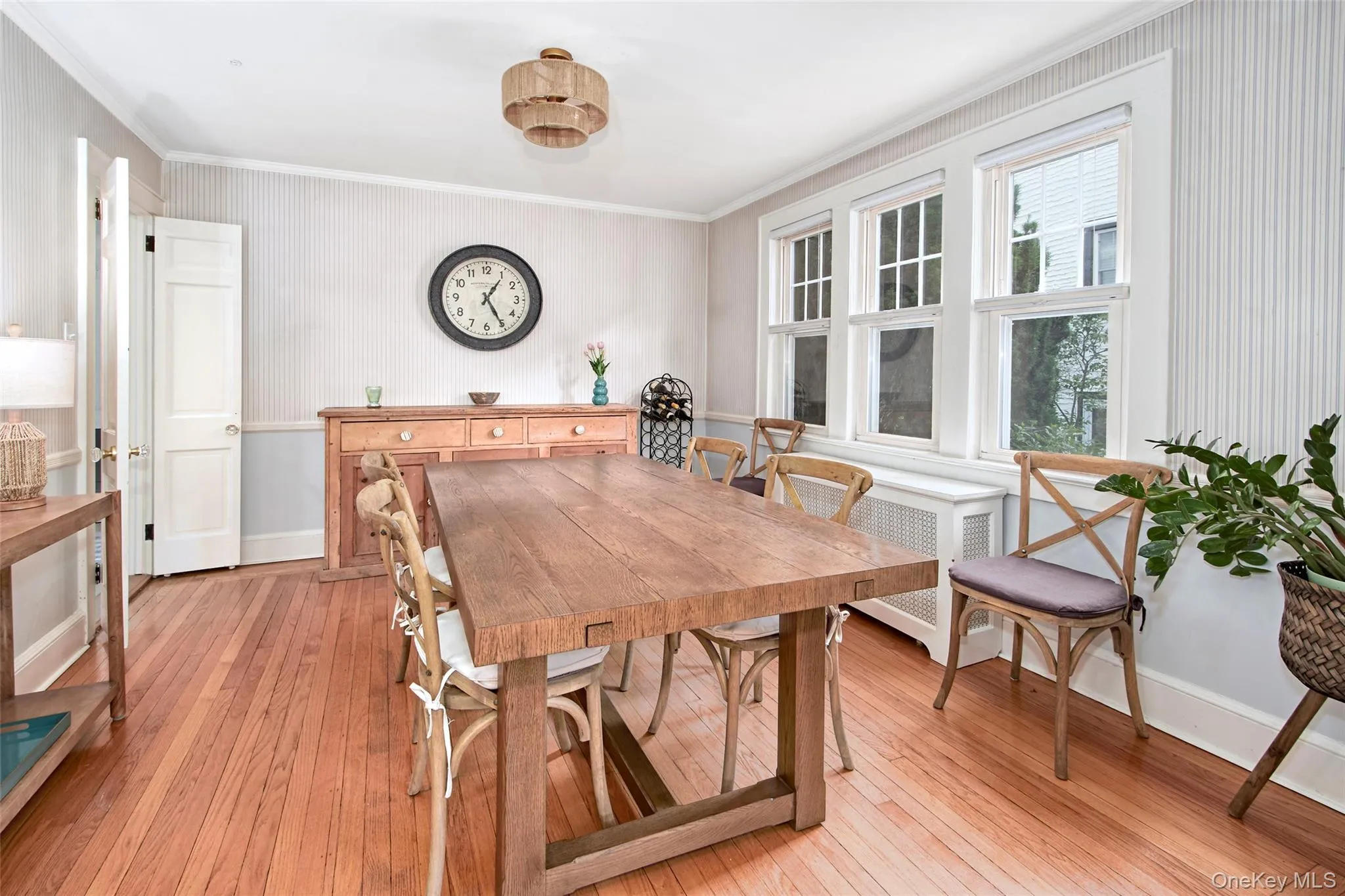 A bright and inviting dining room designed for both everyday living and entertaining. Oversized windows fill the space with natural light, highlighting the warm hardwood floors and creating a welcoming atmosphere. A bright and inviting dining room designed for both everyday living and entertaining. Oversized windows fill the space with natural light, highlighting the warm hardwood floors and creating a welcoming atmosphere.