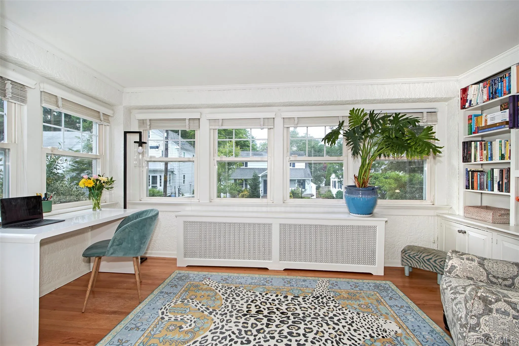 Sun-filled flex space featuring built-in shelving, a dedicated workspace, extensive library, comfortable seating, and multiple windows. Sun-filled flex space featuring built-in shelving, a dedicated workspace, extensive library, comfortable seating, and multiple windows.