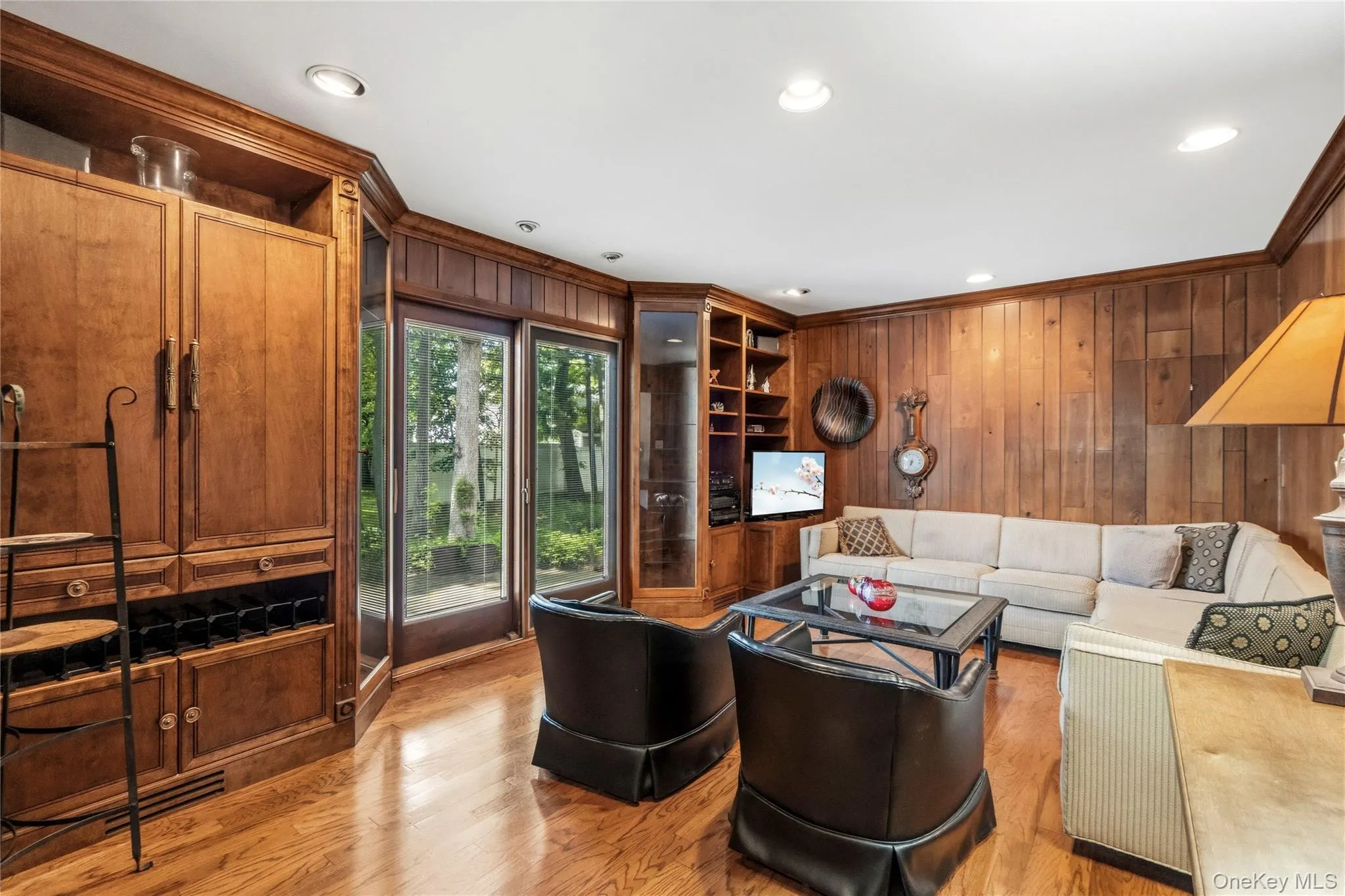 Living area featuring sliders to yard, built-in cabinetry, recessed lighting, and woodf looring Living area featuring sliders to yard, built-in cabinetry, recessed lighting, and woodf looring