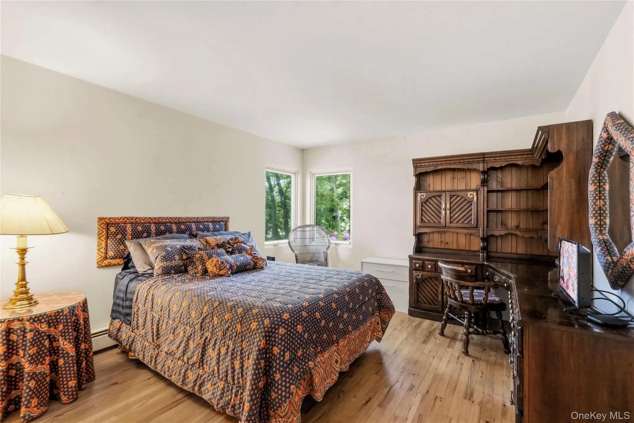 Light-filled room featuring wood-finish flooring and multiple windows Light-filled room featuring wood-finish flooring and multiple windows