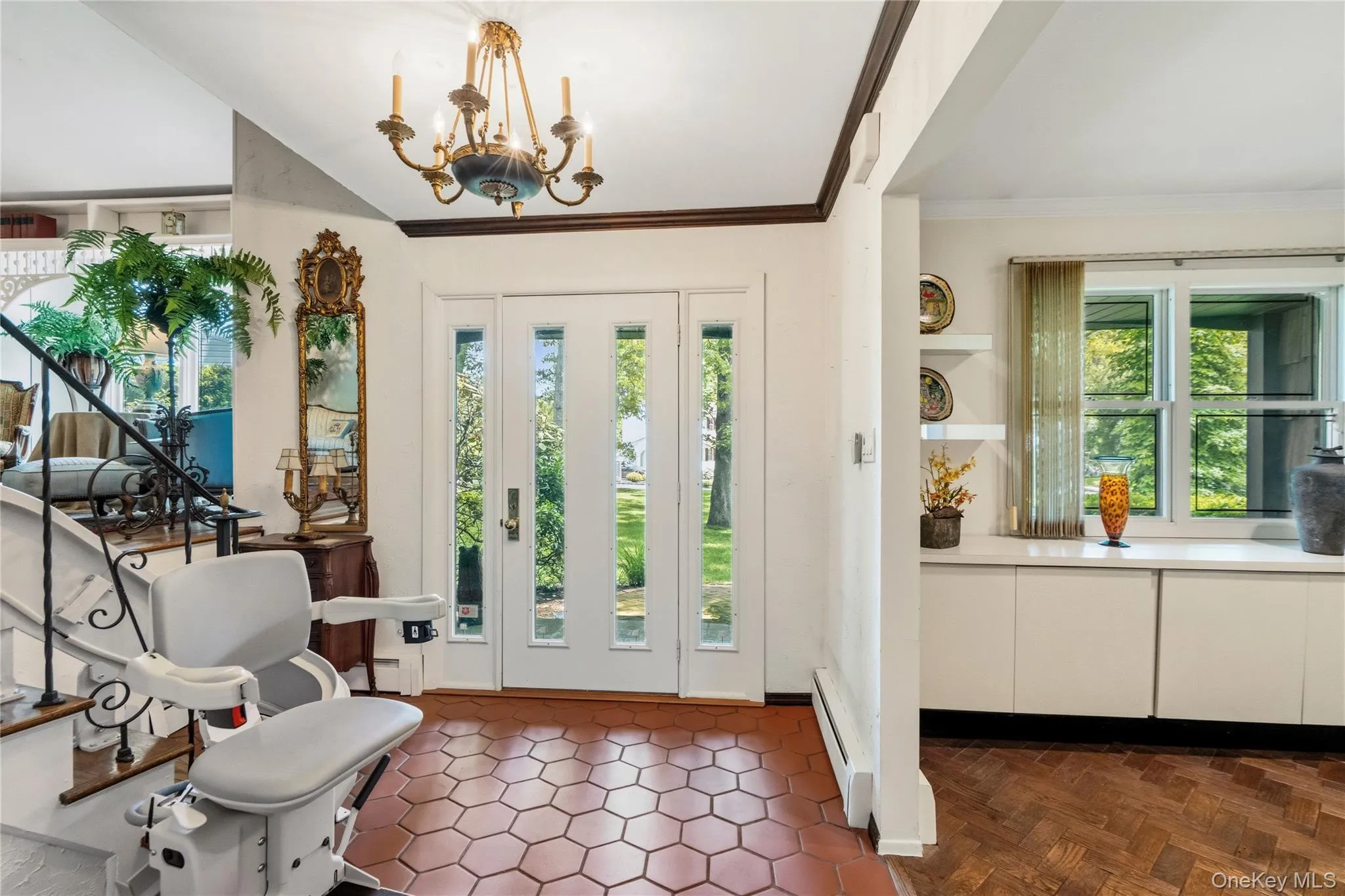Entryway featuring a multi-pane front door with side lights, and a staircase with hardwood floors Entryway featuring a multi-pane front door with side lights, and a staircase with hardwood floors