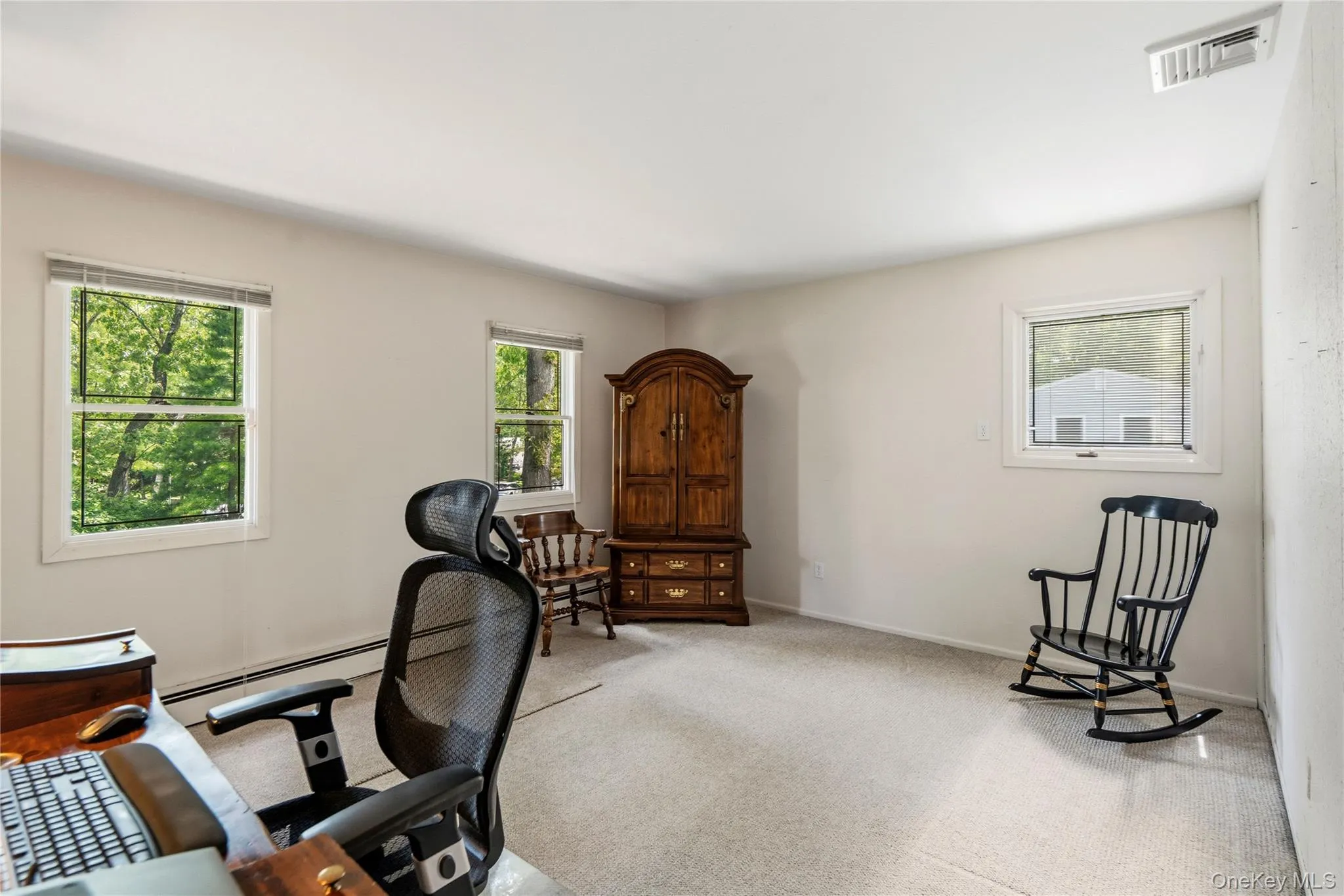 Bright room with multiple windows, and hard wood under carpet Bright room with multiple windows, and hard wood under carpet
