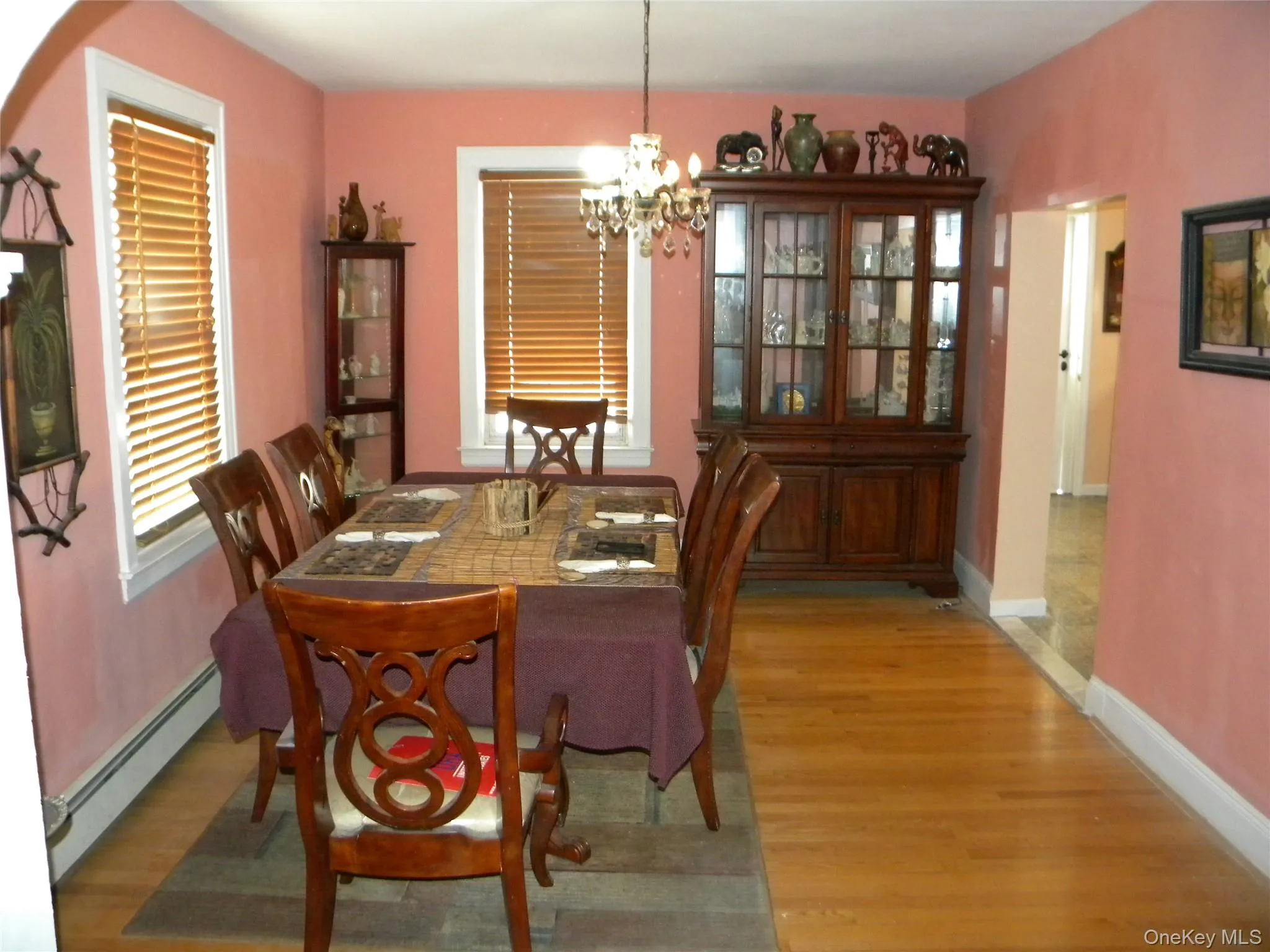 Dining area featuring light wood-finish flooring, white baseboards, and two windows with wood blinds Dining area featuring light wood-finish flooring, white baseboards, and two windows with wood blinds