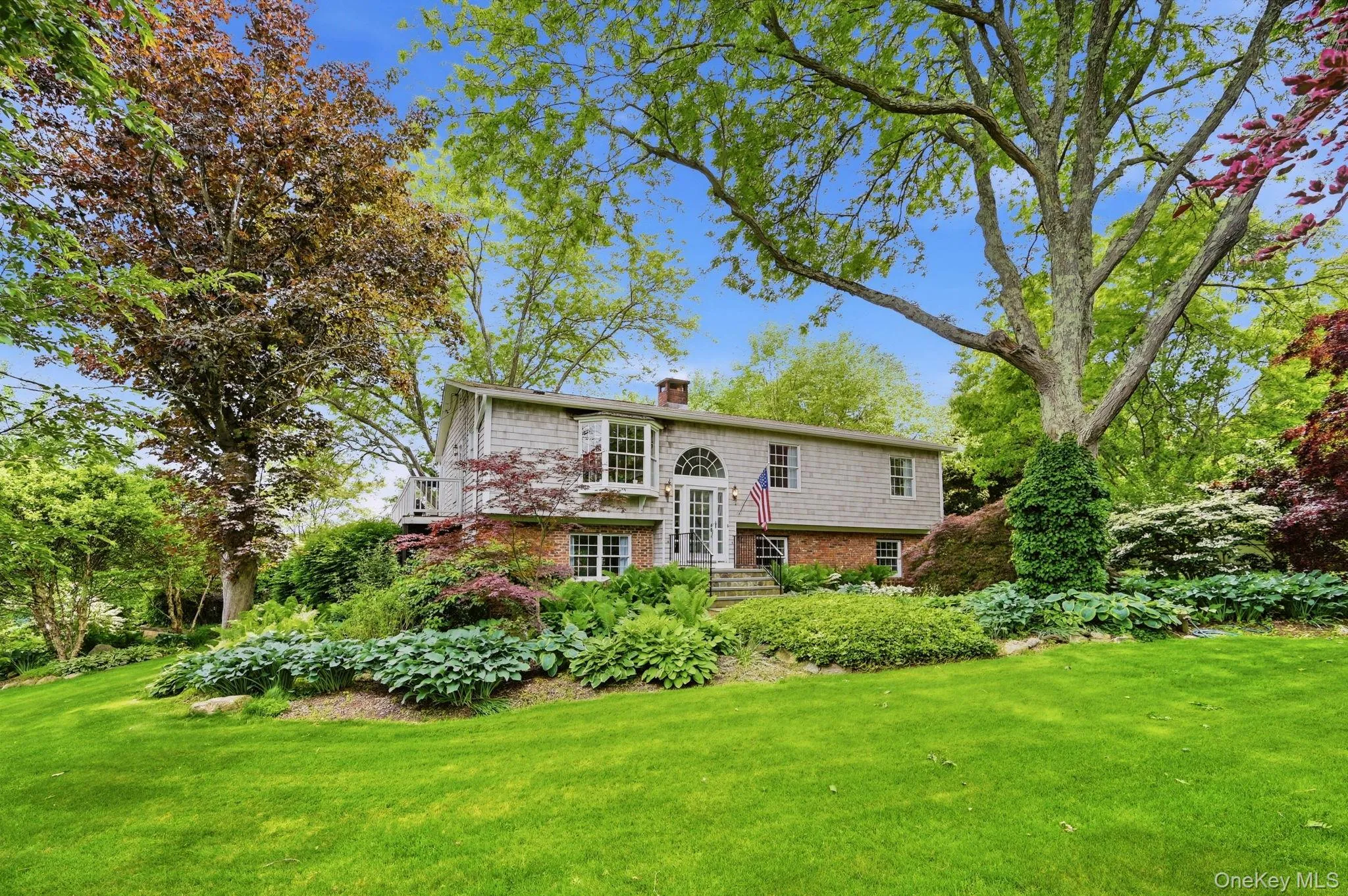 Expansive front lawn with mature trees and diverse landscaping Expansive front lawn with mature trees and diverse landscaping