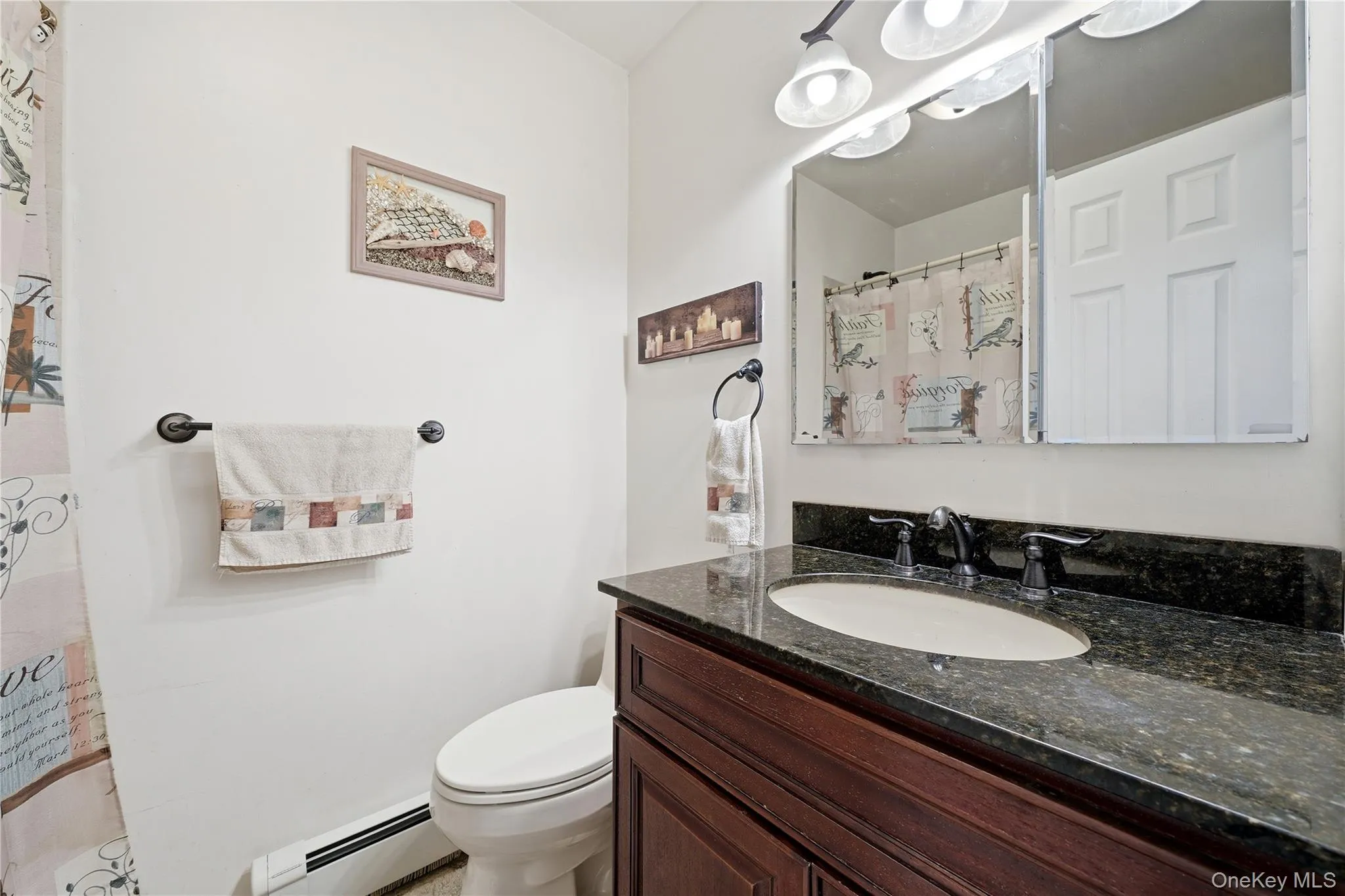 Bathroom vanity with dark countertop, undermount sink, and dark bronze faucet Bathroom vanity with dark countertop, undermount sink, and dark bronze faucet