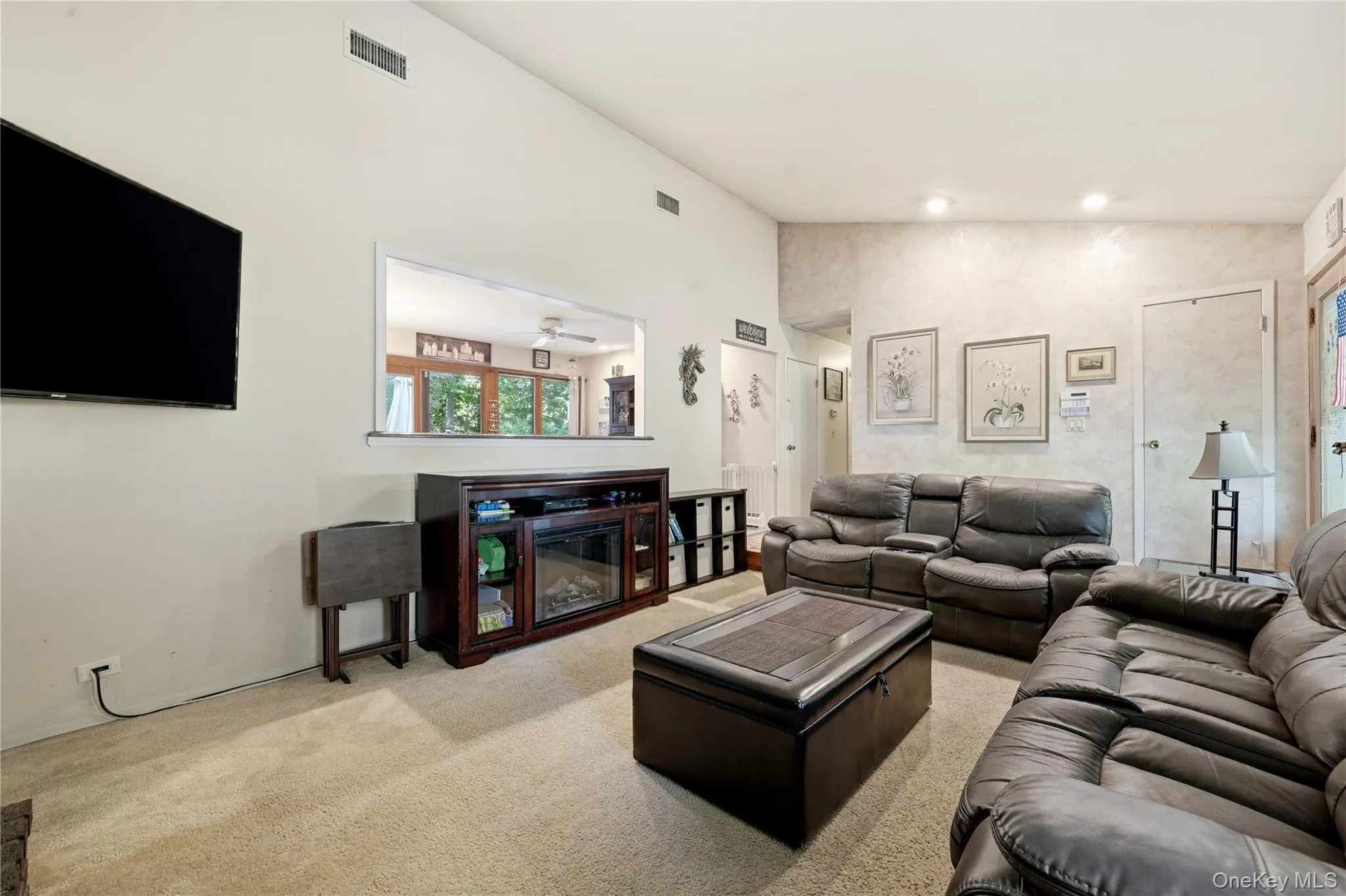 Vaulted ceiling great room with a pass-through window and recessed lighting Vaulted ceiling great room with a pass-through window and recessed lighting