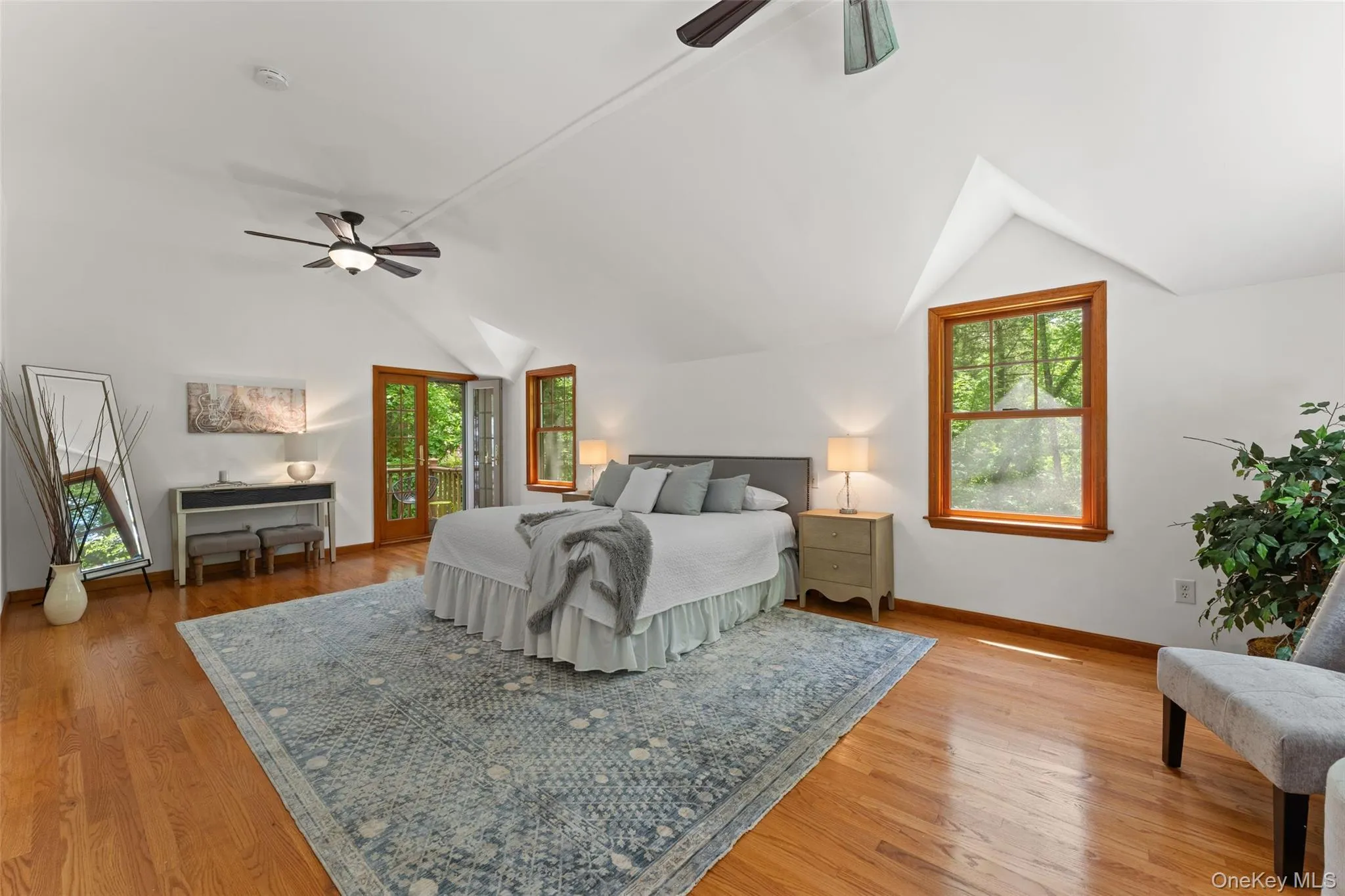 Room featuring wood-finish flooring, vaulted ceilings, and a ceiling fan Room featuring wood-finish flooring, vaulted ceilings, and a ceiling fan