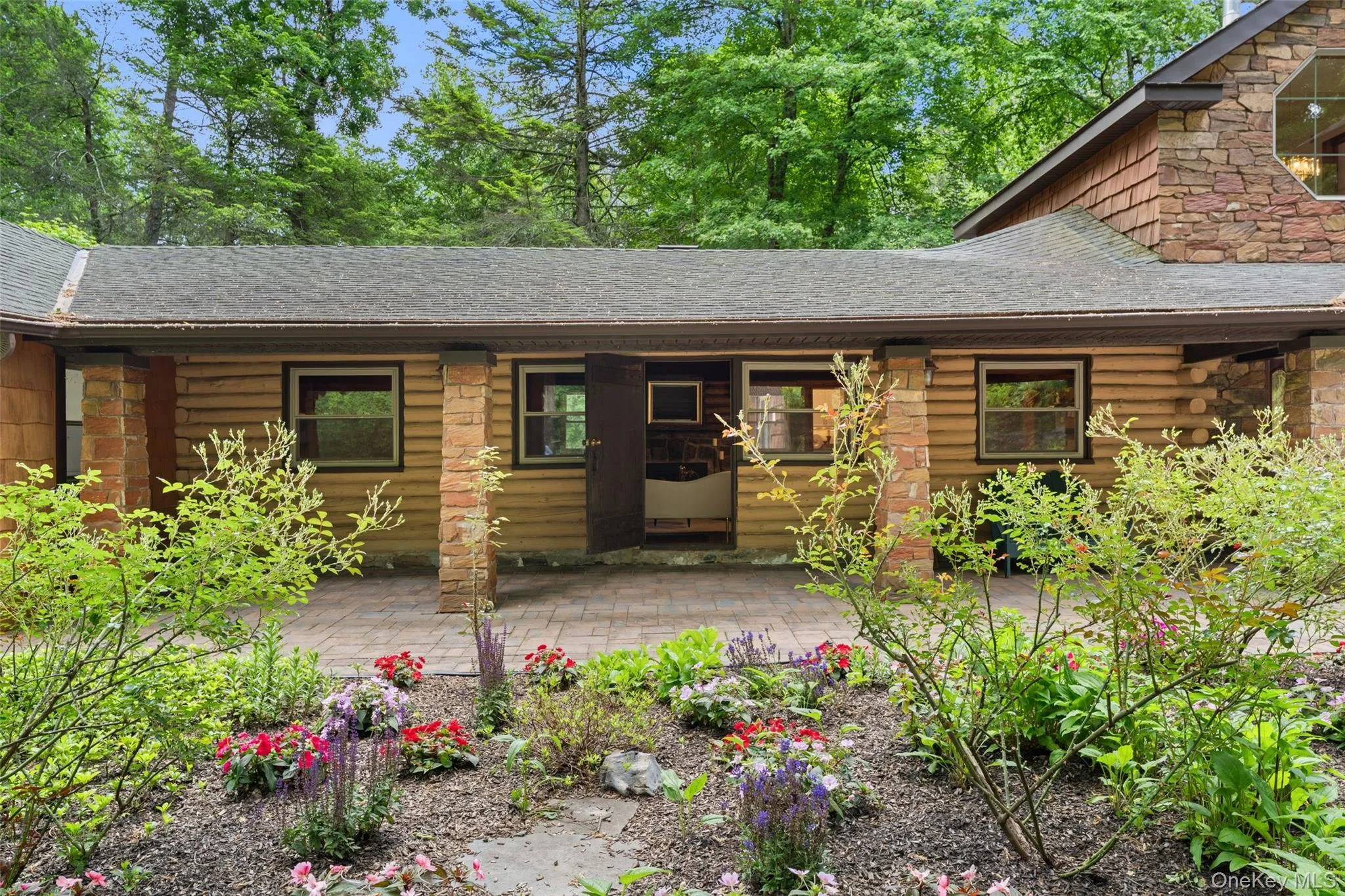 Exterior featuring wood siding, stone accents, and a covered patio Exterior featuring wood siding, stone accents, and a covered patio