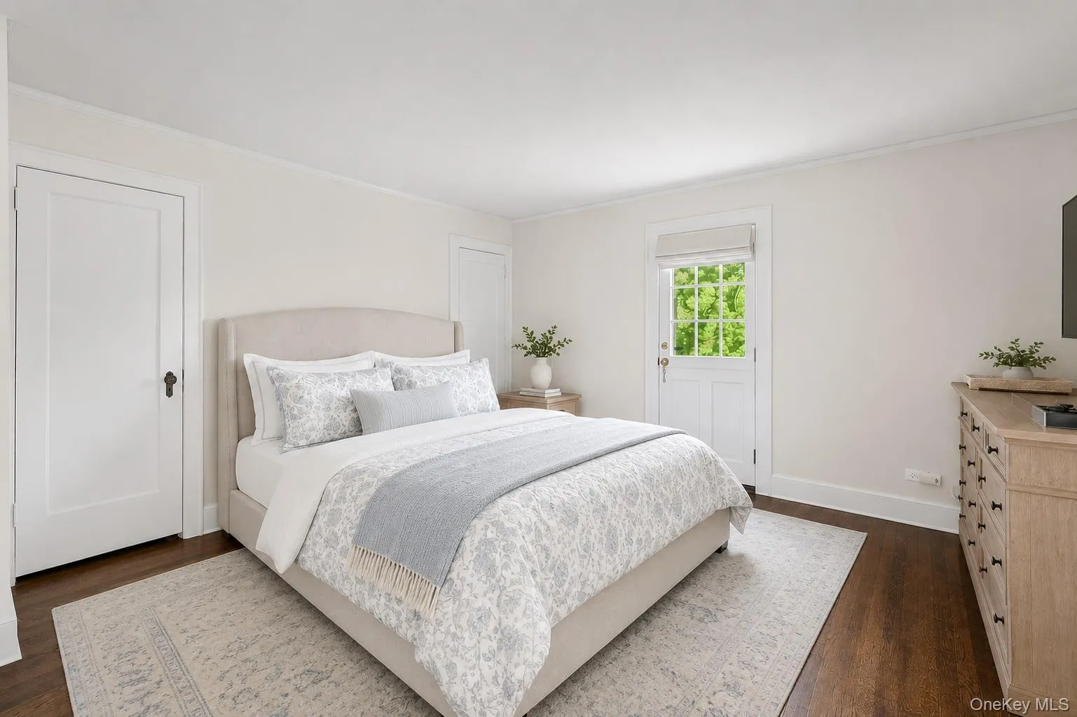 Spacious bedroom featuring 2 closets, an ensuite bathroom, dark wood-finish flooring and light-toned walls with access to 2nd floor terrace. Spacious bedroom featuring 2 closets, an ensuite bathroom, dark wood-finish flooring and light-toned walls with access to 2nd floor terrace.