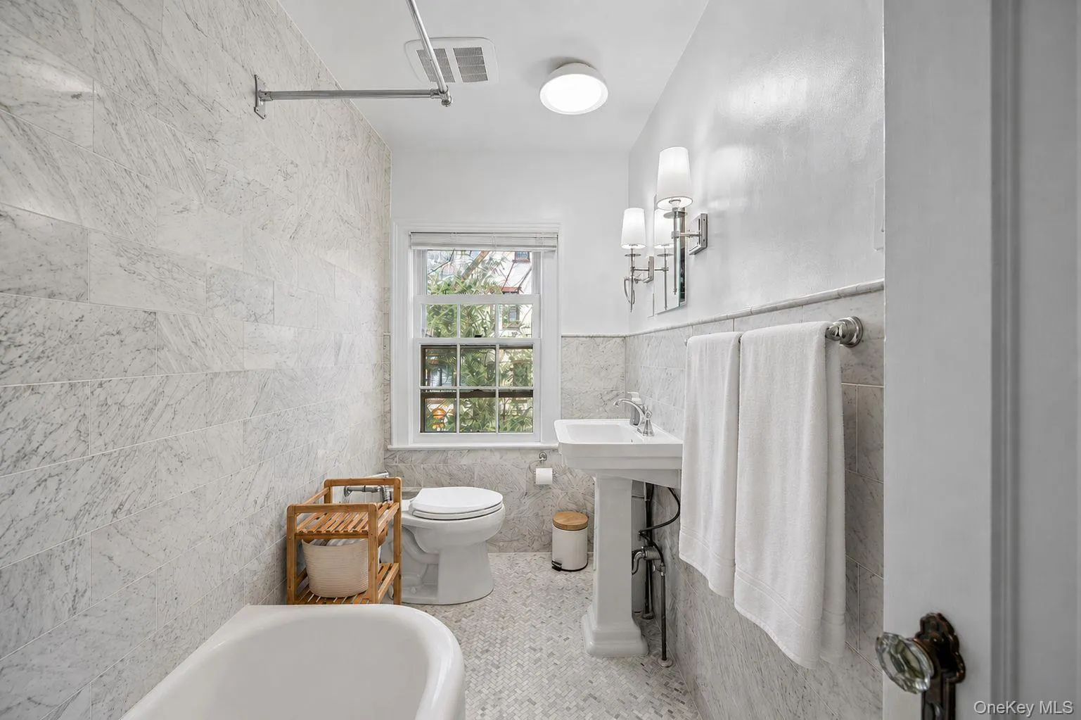 2nd floor bathroom featuring a white pedestal sink, polished chrome fixtures, and a wall-mounted vanity light 2nd floor bathroom featuring a white pedestal sink, polished chrome fixtures, and a wall-mounted vanity light