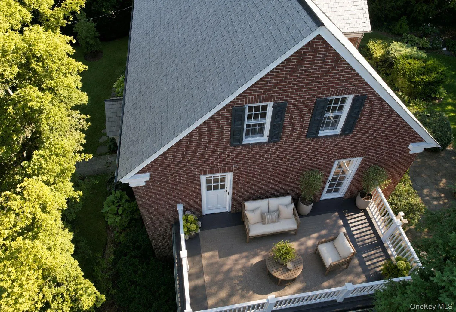 Aerial view of 2nd floor terrace/balcony (accessed by 2 bedrooms) with brick exterior featuring white trim and dark shutters Aerial view of 2nd floor terrace/balcony (accessed by 2 bedrooms) with brick exterior featuring white trim and dark shutters