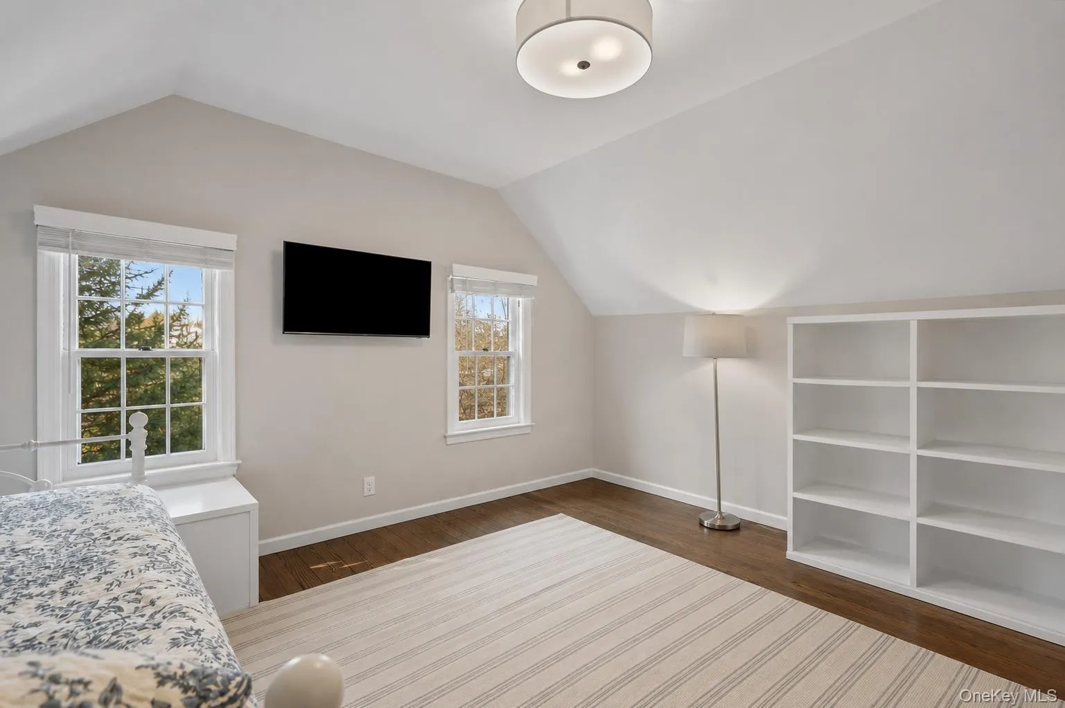 Top floor/attic bedroom featuring vaulted ceilings and dark wood-finish flooring Top floor/attic bedroom featuring vaulted ceilings and dark wood-finish flooring
