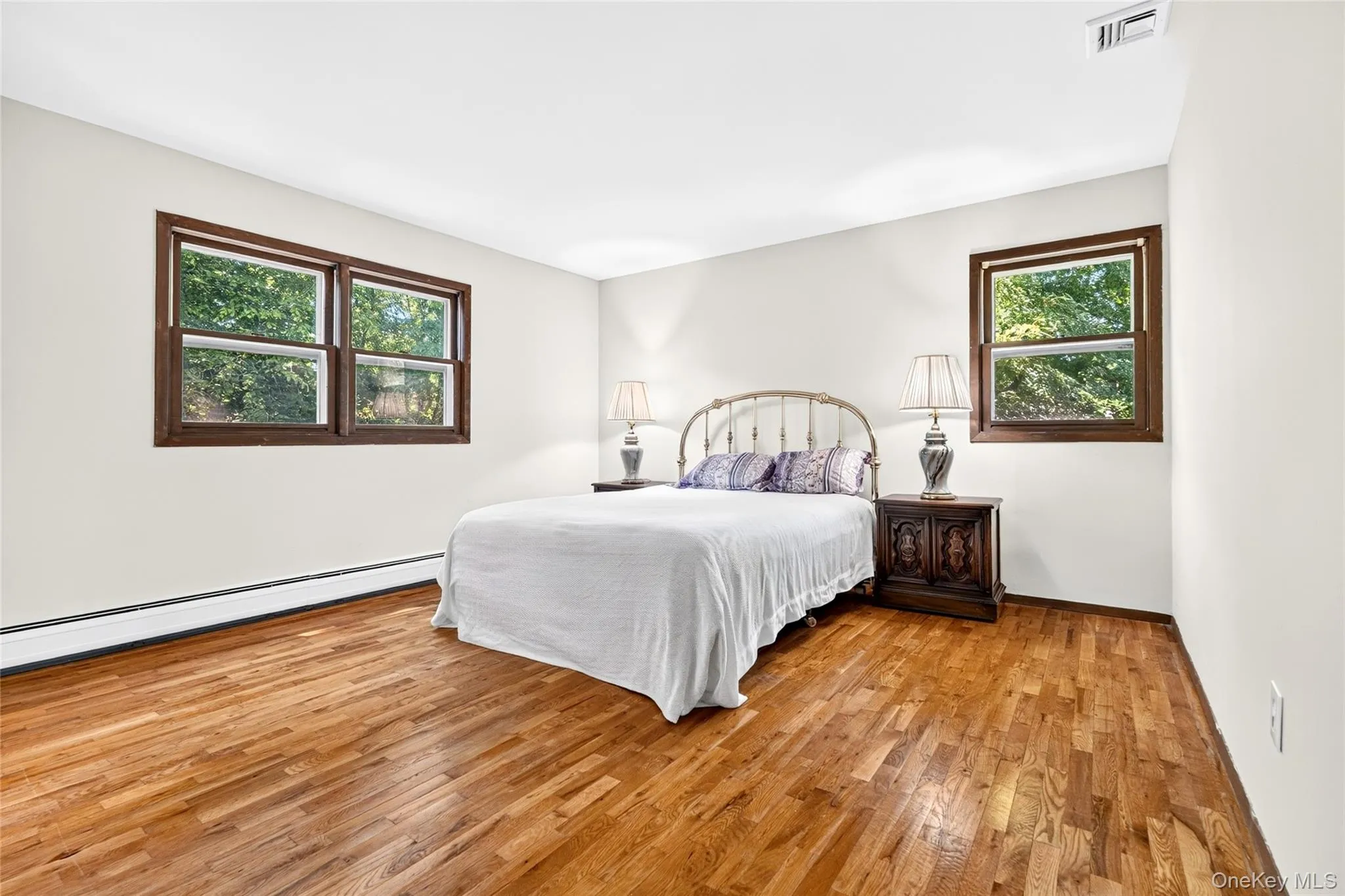 Primary bedroom with gleaming hardwood floors Primary bedroom with gleaming hardwood floors