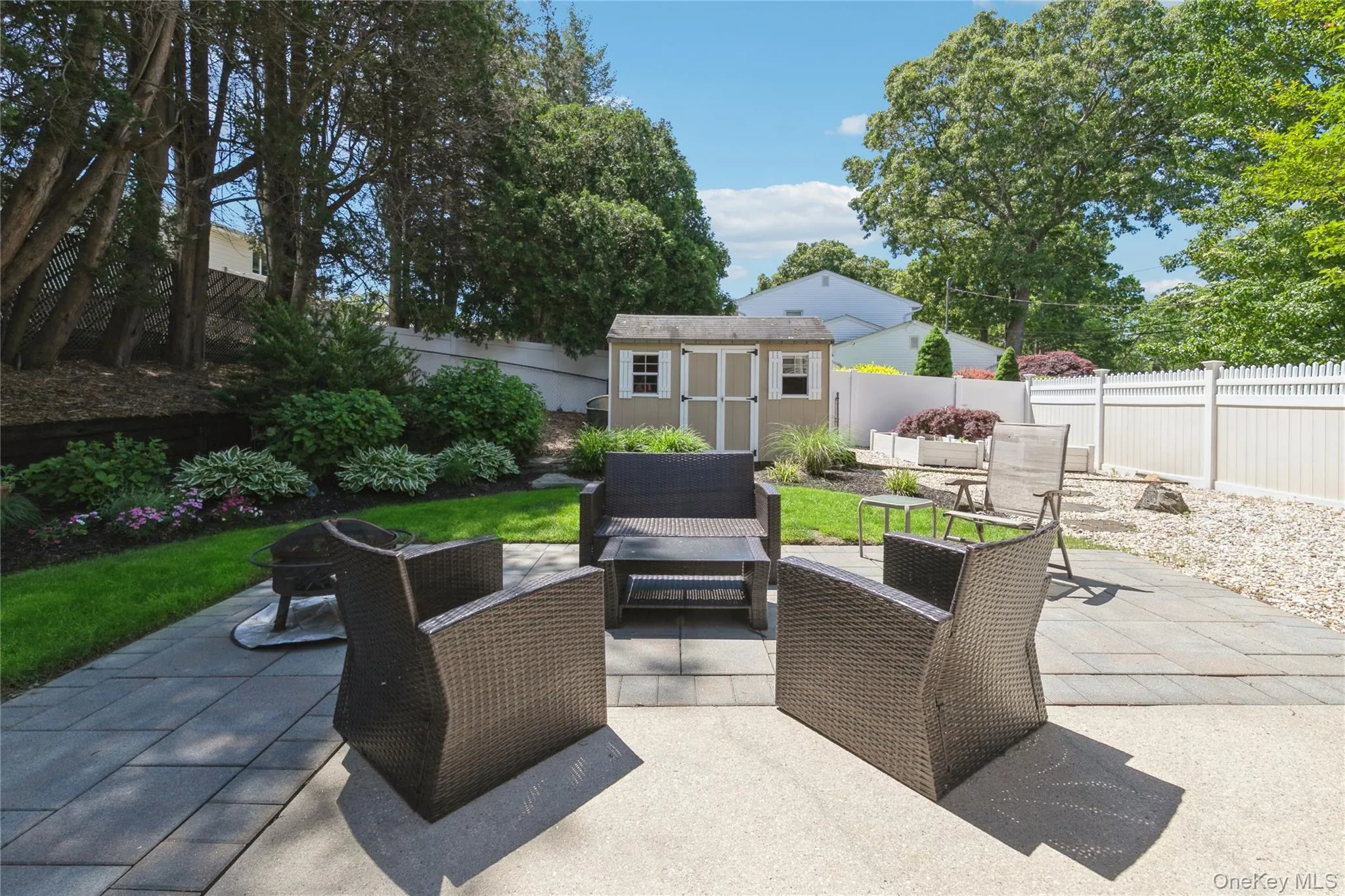 Expansive paver patio with a separate gravel area and a dedicated lawn space Expansive paver patio with a separate gravel area and a dedicated lawn space