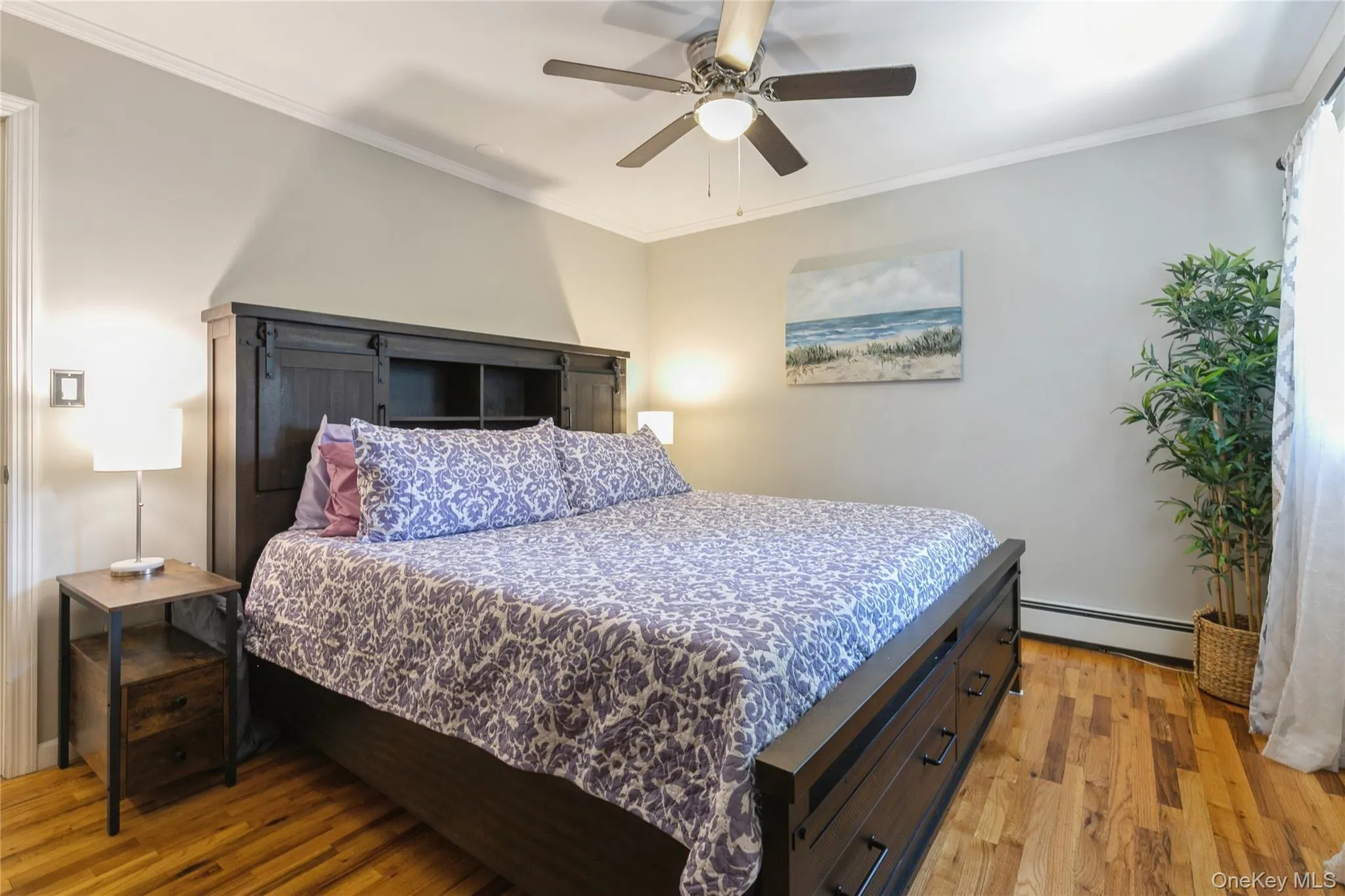 Hardwood flooring throughout featuring a ceiling fan with integrated lighting, crown molding, and a window with natural light Hardwood flooring throughout featuring a ceiling fan with integrated lighting, crown molding, and a window with natural light