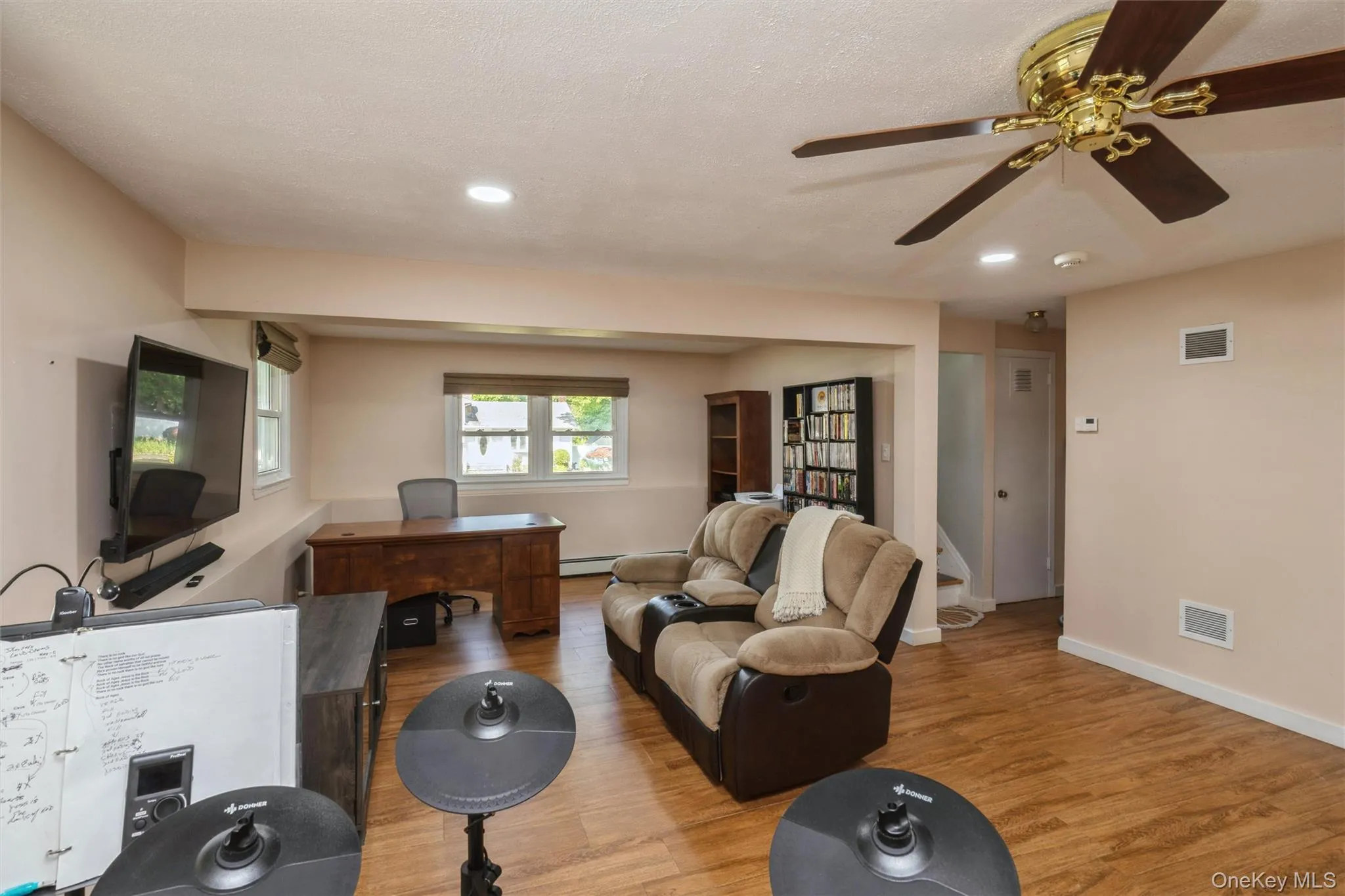 Spacious room featuring wood-finish flooring, recessed lighting, and a ceiling fan Spacious room featuring wood-finish flooring, recessed lighting, and a ceiling fan