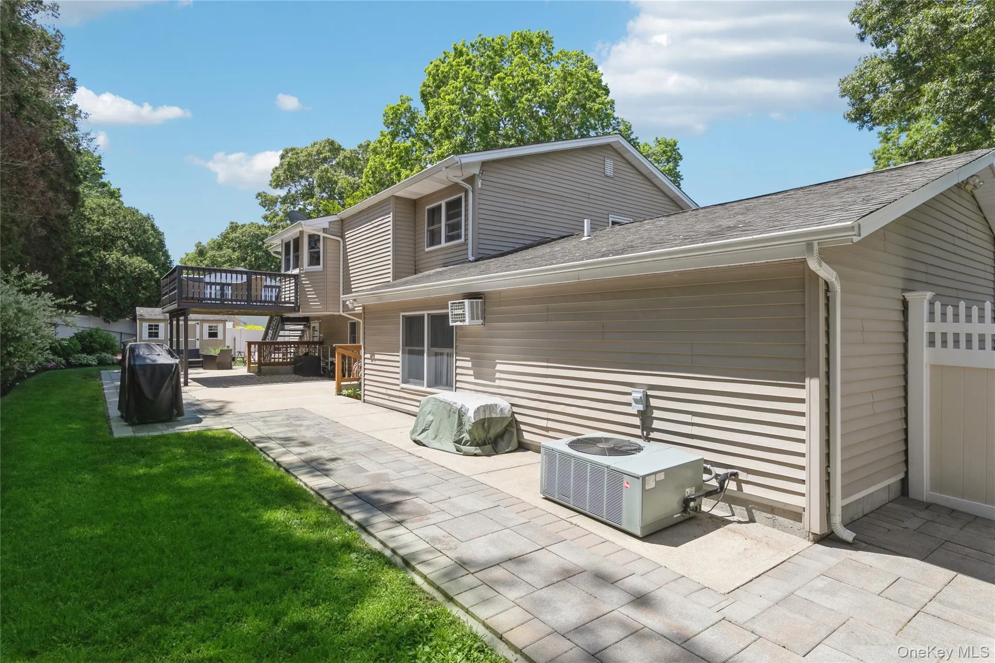 Expansive paver patio with a manicured lawn border Expansive paver patio with a manicured lawn border