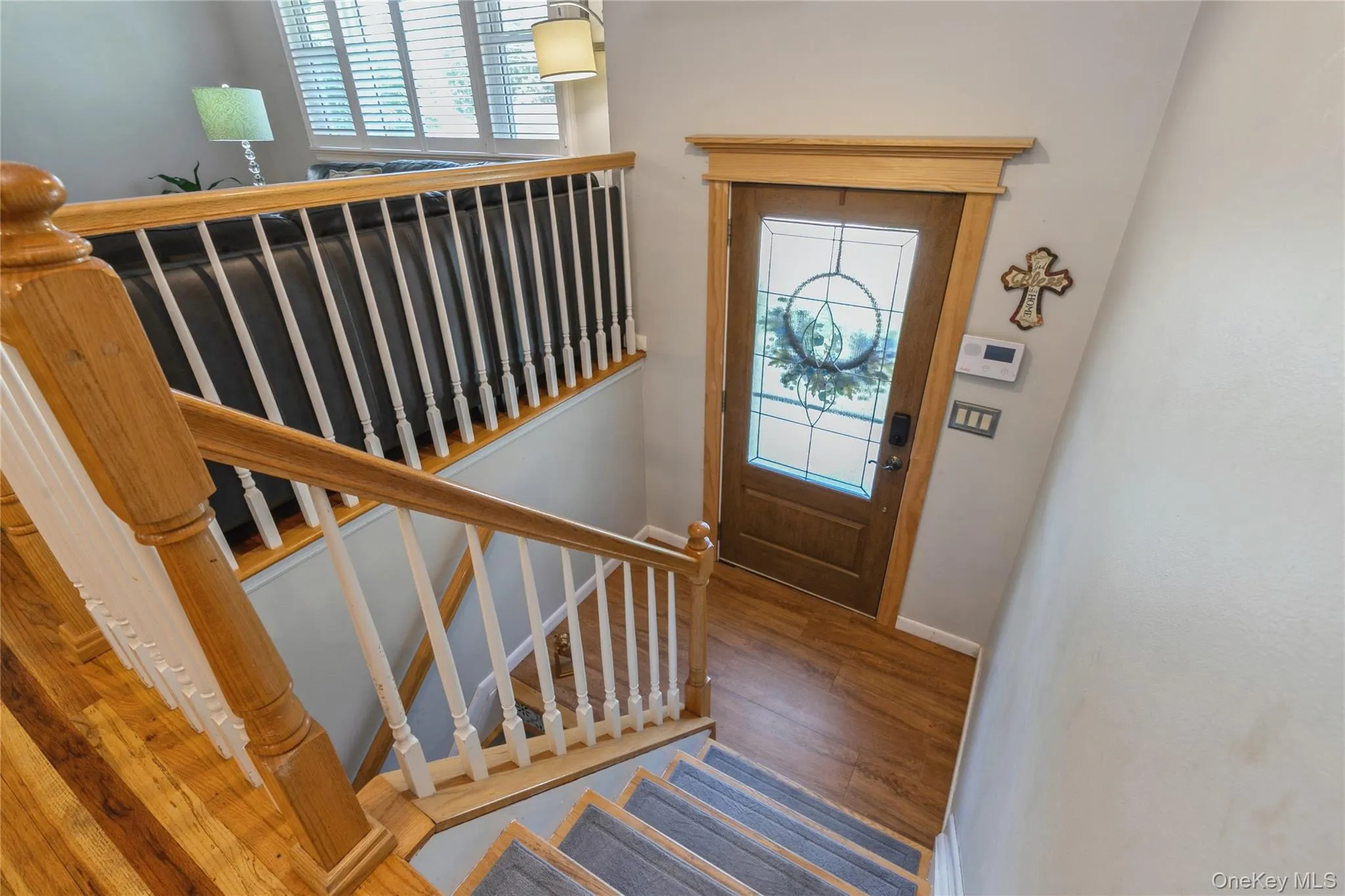 Entryway featuring a wood-finish door with leaded glass, framed by natural wood trim Entryway featuring a wood-finish door with leaded glass, framed by natural wood trim