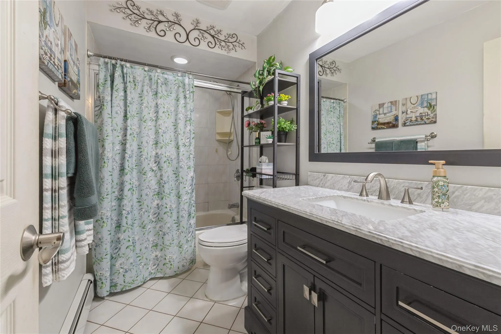 Bathroom featuring a dark wood-finish vanity with a light countertop, a rectangular undermount sink, and a framed mirror Bathroom featuring a dark wood-finish vanity with a light countertop, a rectangular undermount sink, and a framed mirror