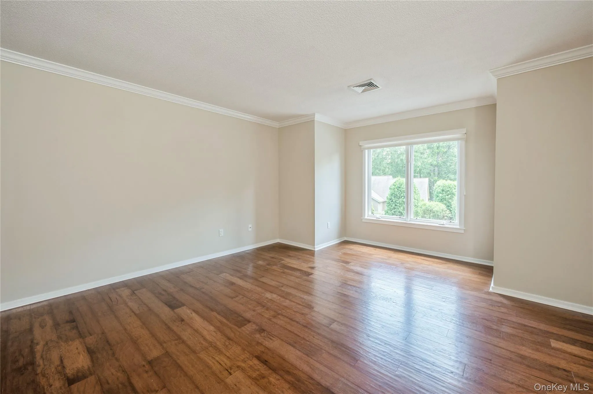 Primary Bedroom with crown molding and wood finished floors Primary Bedroom with crown molding and wood finished floors
